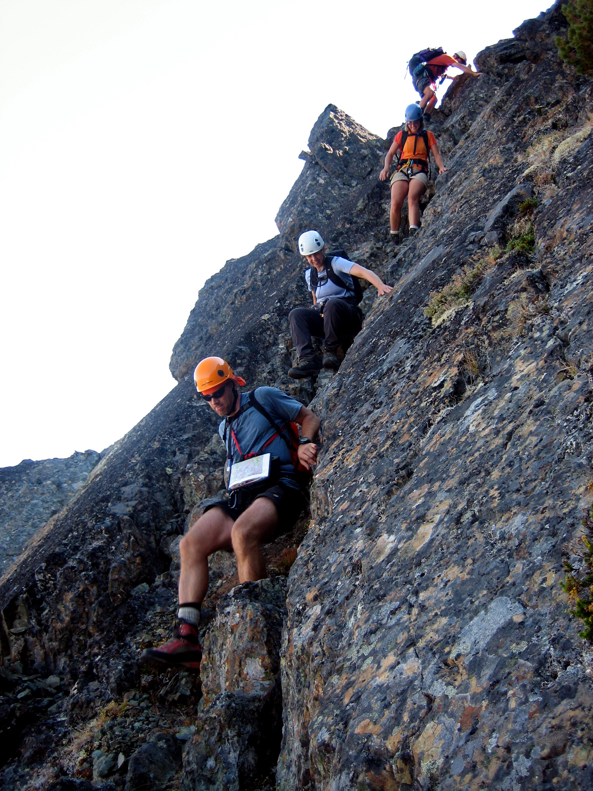 mountain climbers scrambling down a rocky slot on Mt Clark in the Olympic Mountain National Park