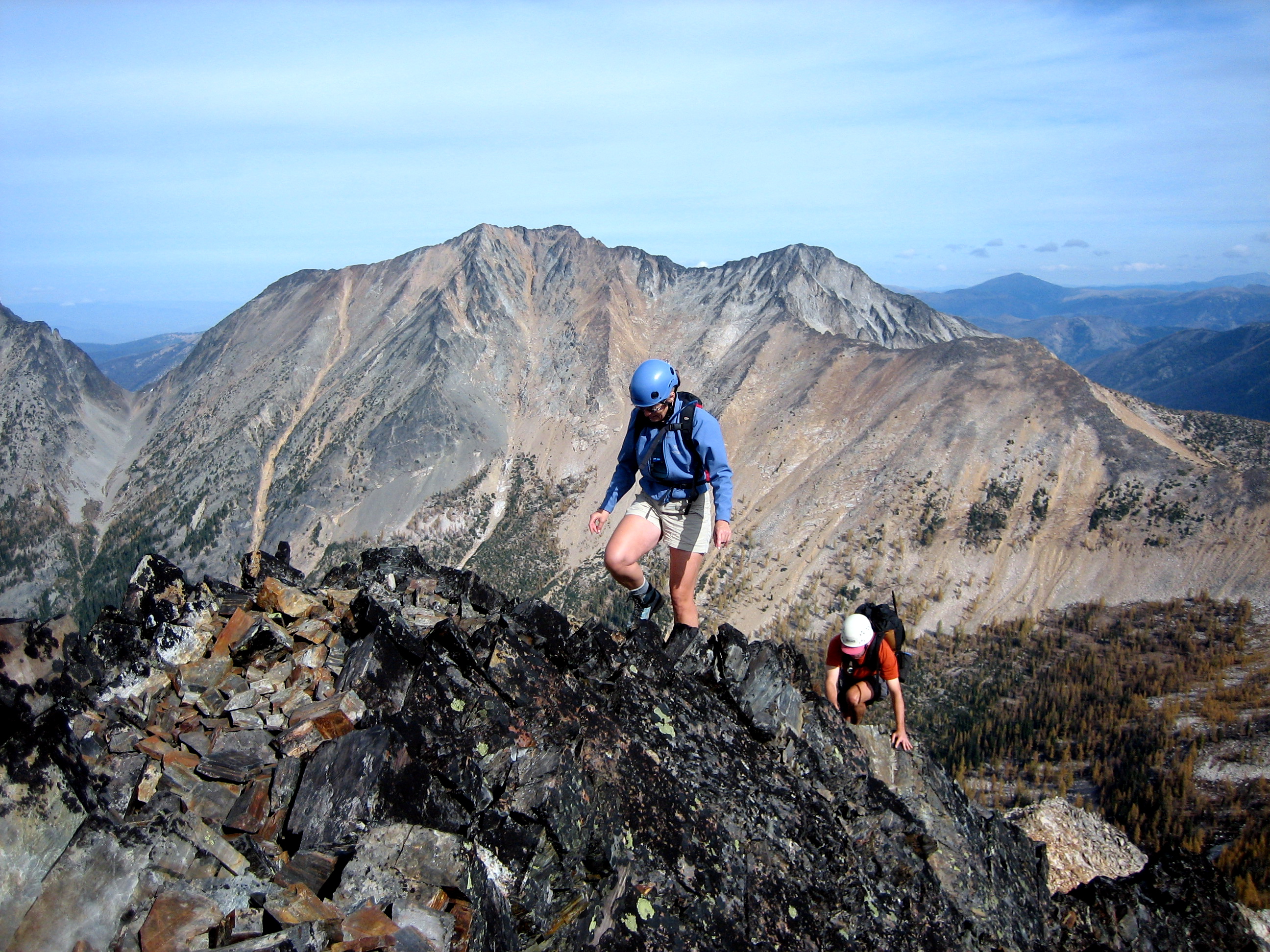 Two climbers step onto a rocky summit of Blackcap Mountain in the Pasayten Wilderness