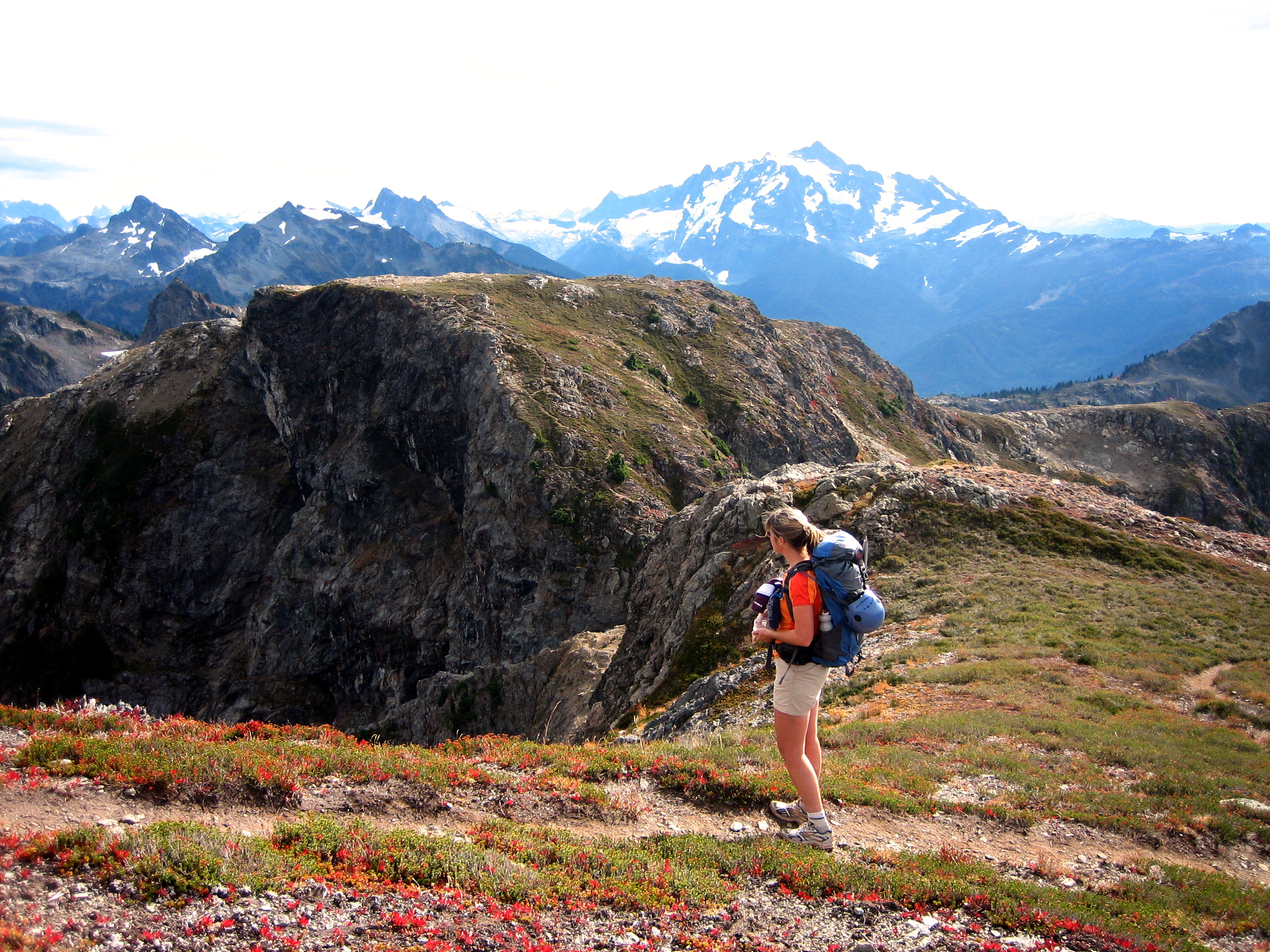 mountain climber on the trail leading up the fall colored ridge of Tomyhoi Peak in the Nooksack Mountains