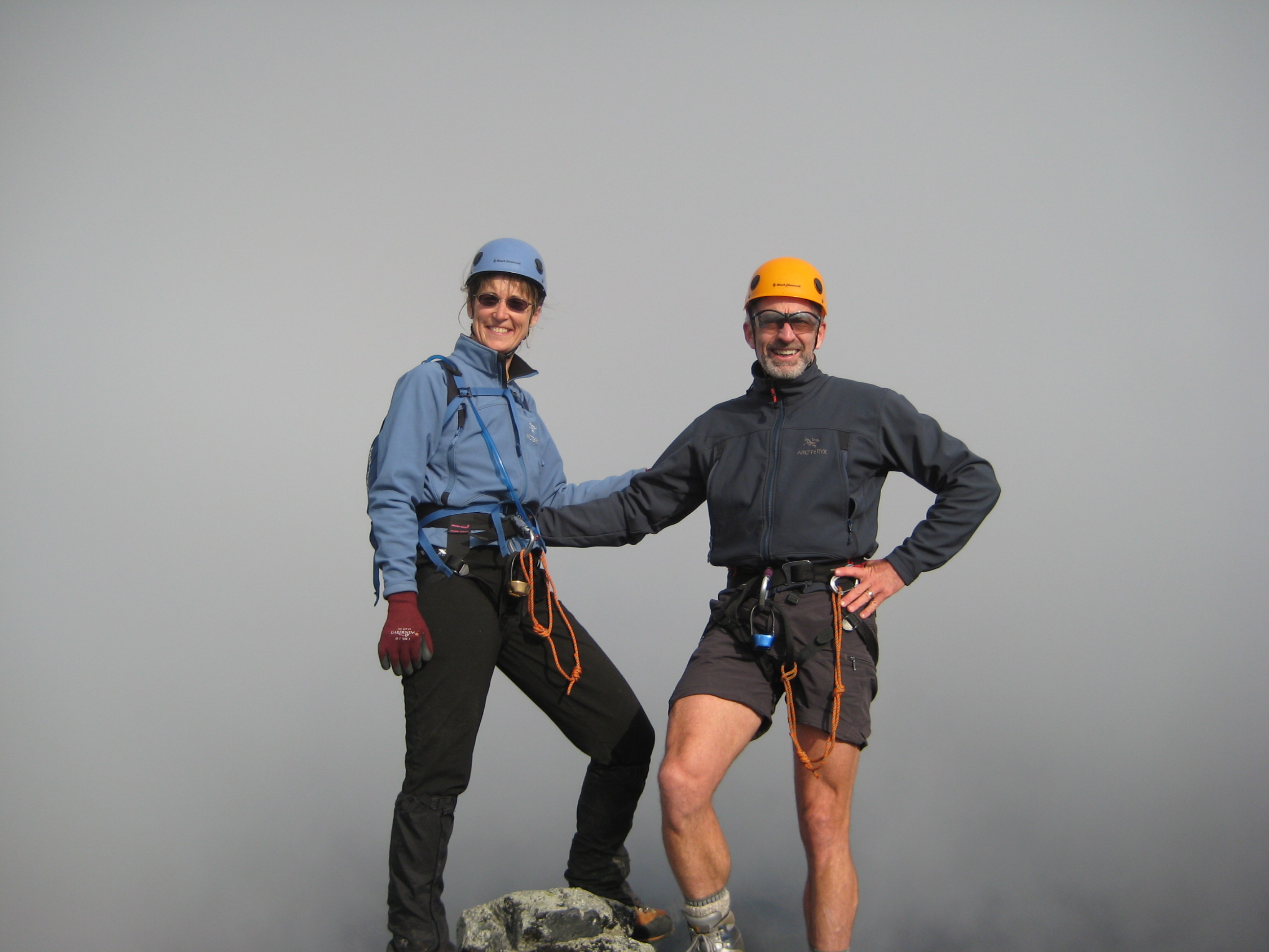 mountain climbers stand in the fog on the summit of FIsher Peak in North Cascades National Park