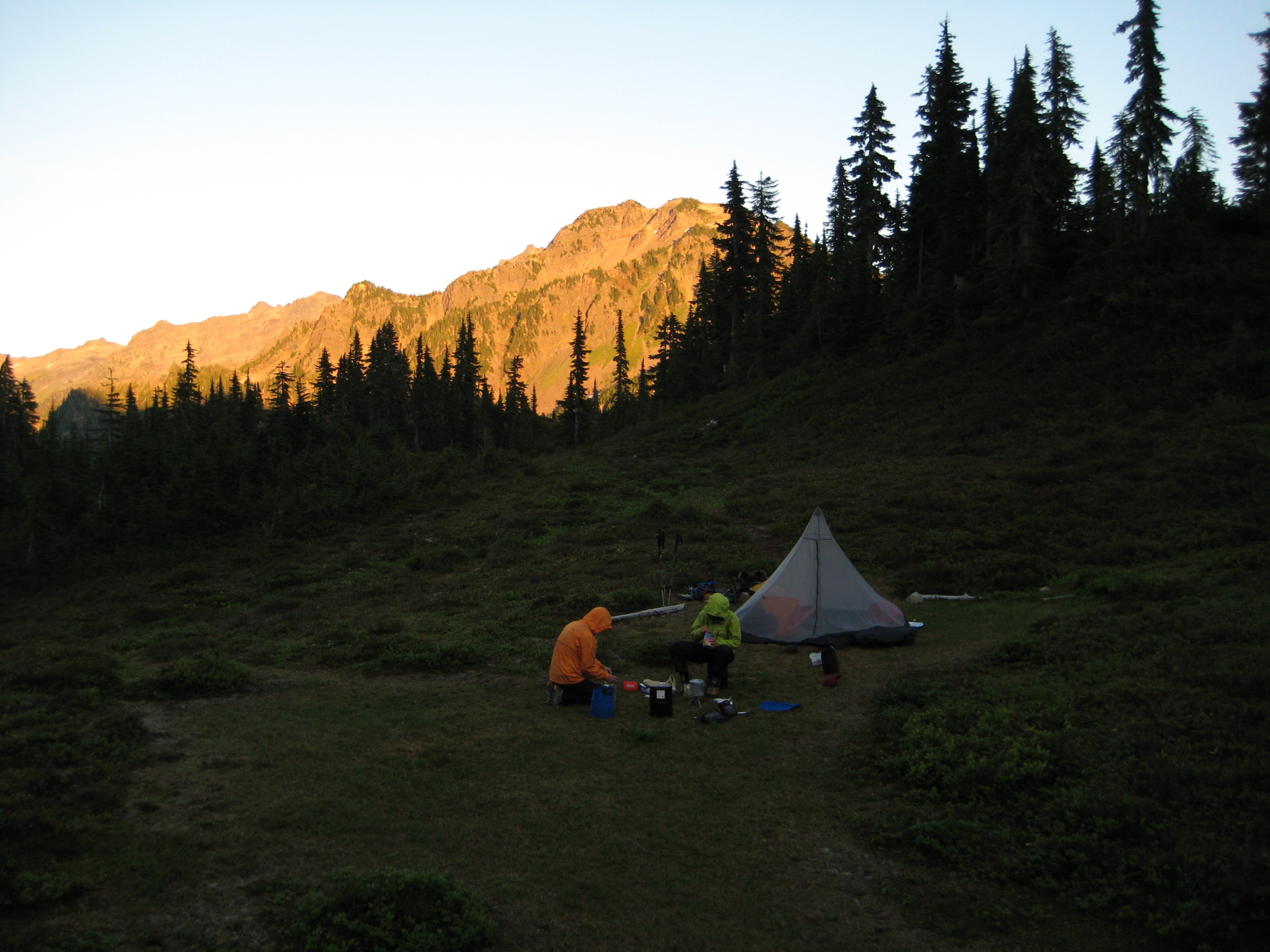 mountain climber camp in Cat Basin with evening light on the hillside in the distance in Olympic National Park