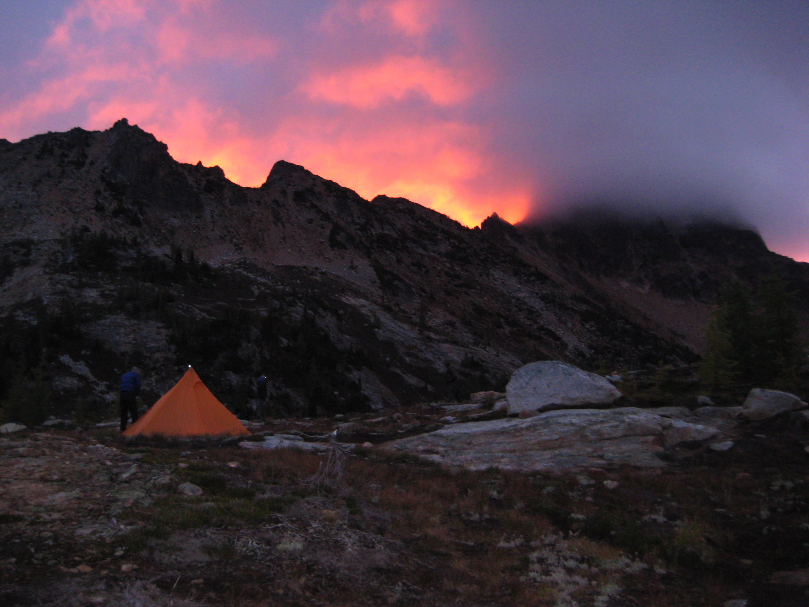 sunset firey light above Tower Mountain in the Upper Methow Mountains with mountain climber's camp on the rock slabs of Snowy Lakes 