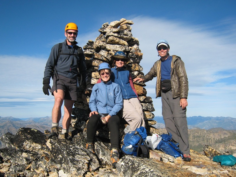group of mountain climbers in front of rock cairn on the summit of Tower Mountain in the Upper Methow Mountains