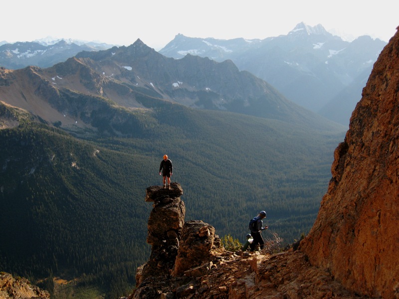 mountain climber standing on rock generarme on the shoulder of Tower Mountain with the Upper Methow Mountains in the distance