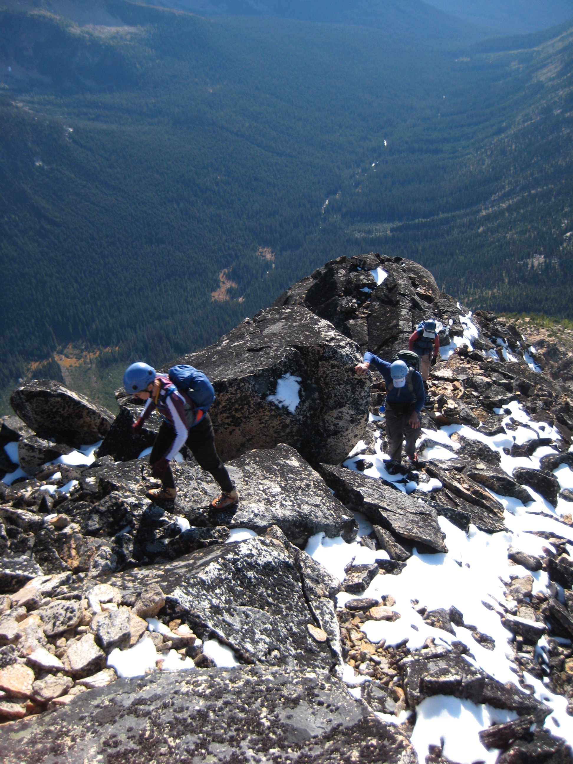 mountain climbers scrambling rock slabs through a dusting of snow on Tower Mountain in the Upper Methow Mountains