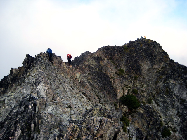 mountain climbers scrambling the rocky summit ridge of Fisher Peak in North Cascades National Park