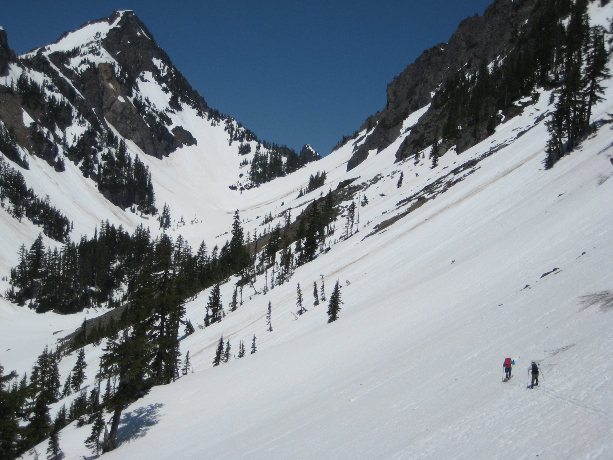 backcountry skiers traversing steep snow slope heading to Melakwa Pass on the Chair Peak Circumnavigation Ski Tour