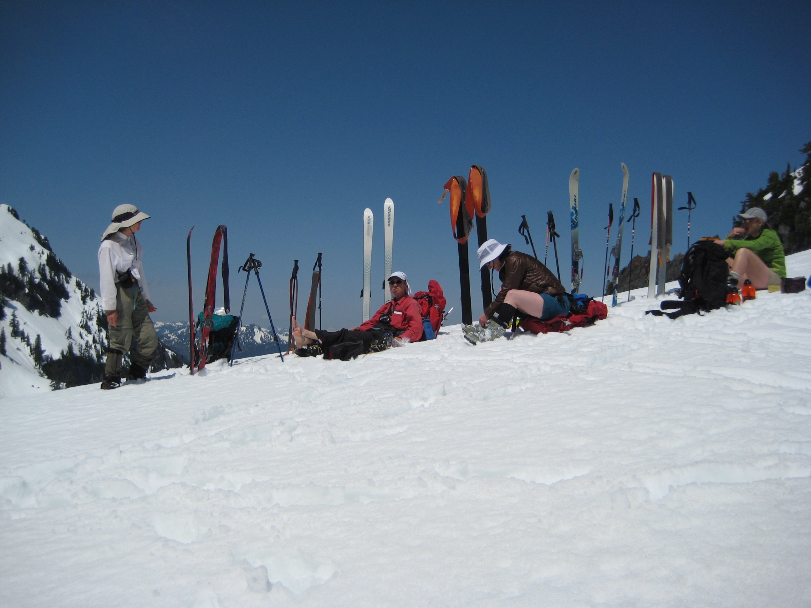 backcountry skiers relaxing on the snow at Melakwa Pass during the Chair Peak Circumnavigation Ski Tour