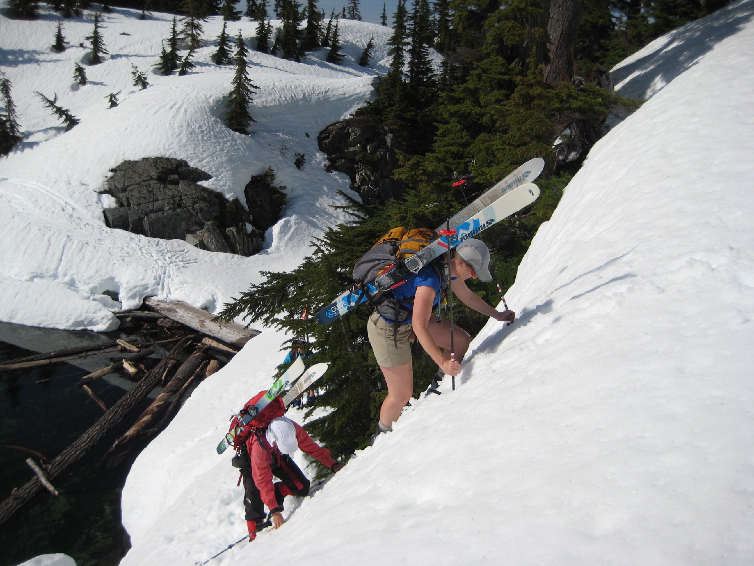 backcountry skiers carrying their skis and booting up steep snow on the Chair Peak Circumnavigation Ski Tour