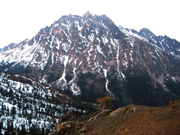 Looking across Ingalls Creek Valley at Mt Stuart streaked with vertical ribbons of snow as seen from Longs Pass