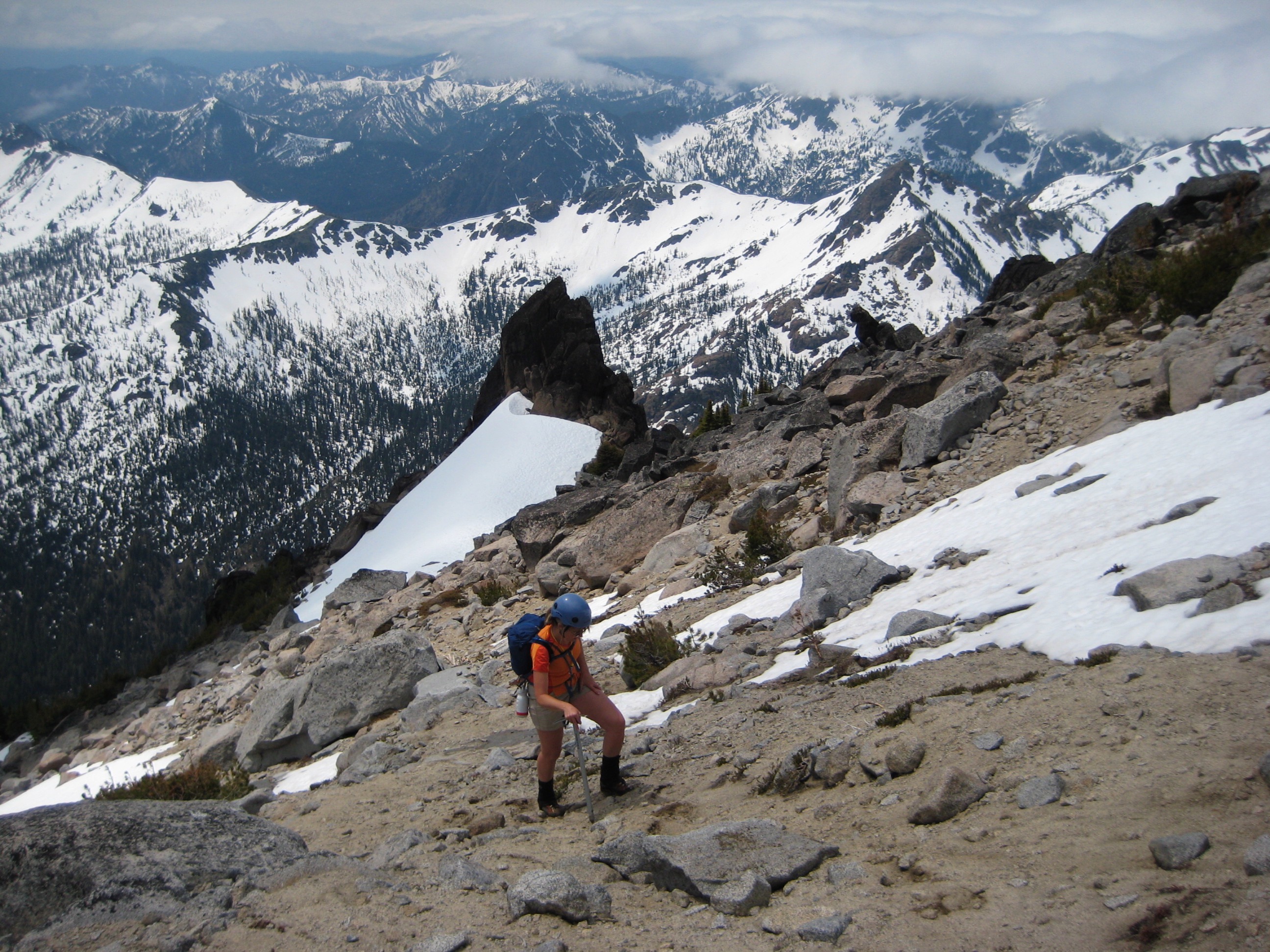 mountain climber hiking up dirt and snow in the Cascadian Basin on Mt Stuart in the Icicle Mountains