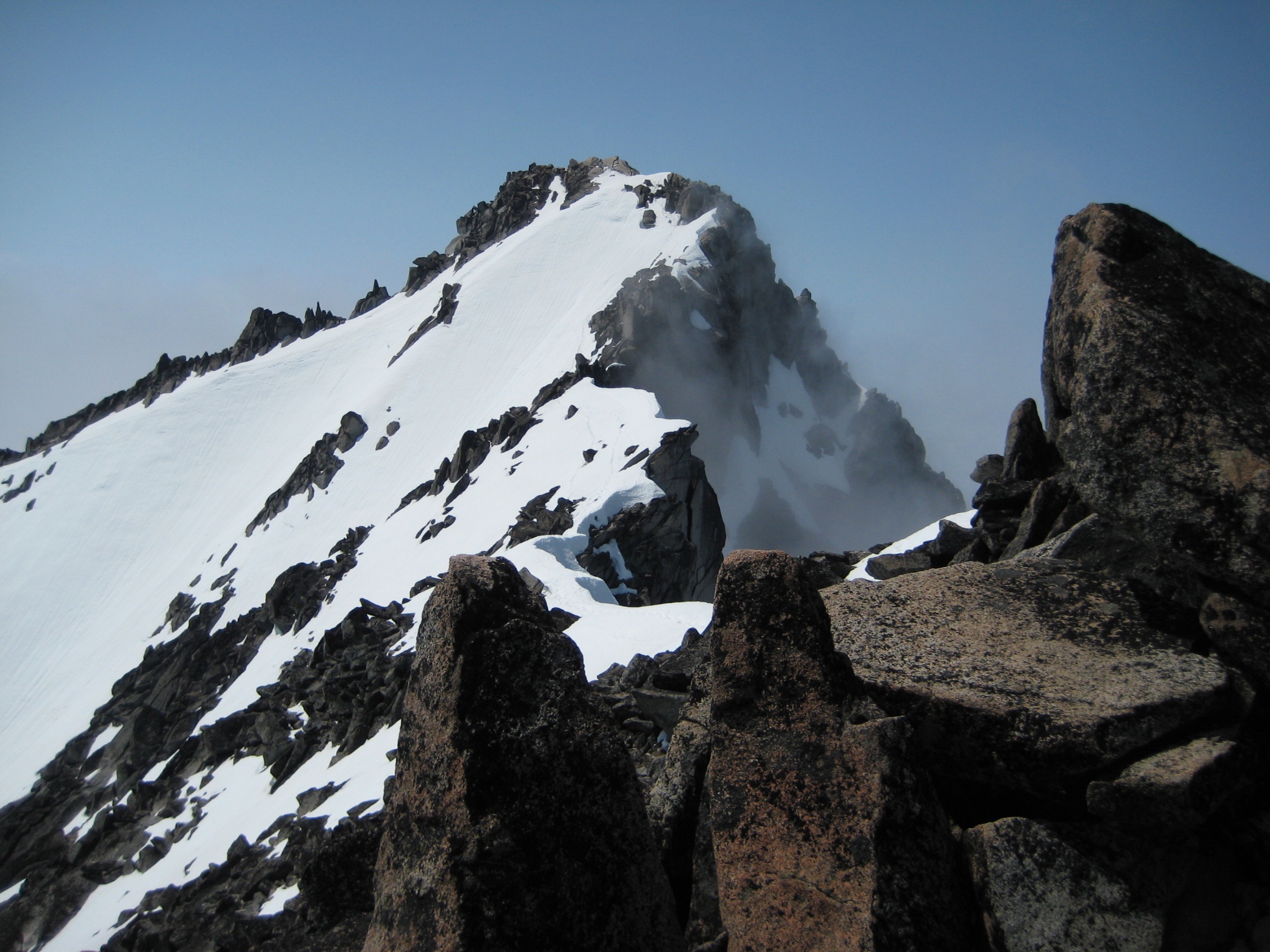 summit of Mt Stuart covered with snow as seen from the falase summit in the Icicle Mountains