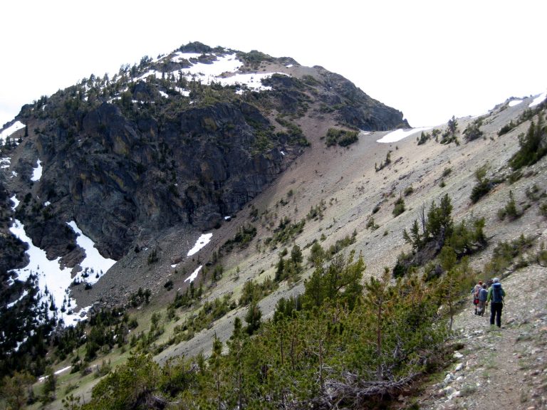 Hikers follow a trail toward Three Brothers Mountain