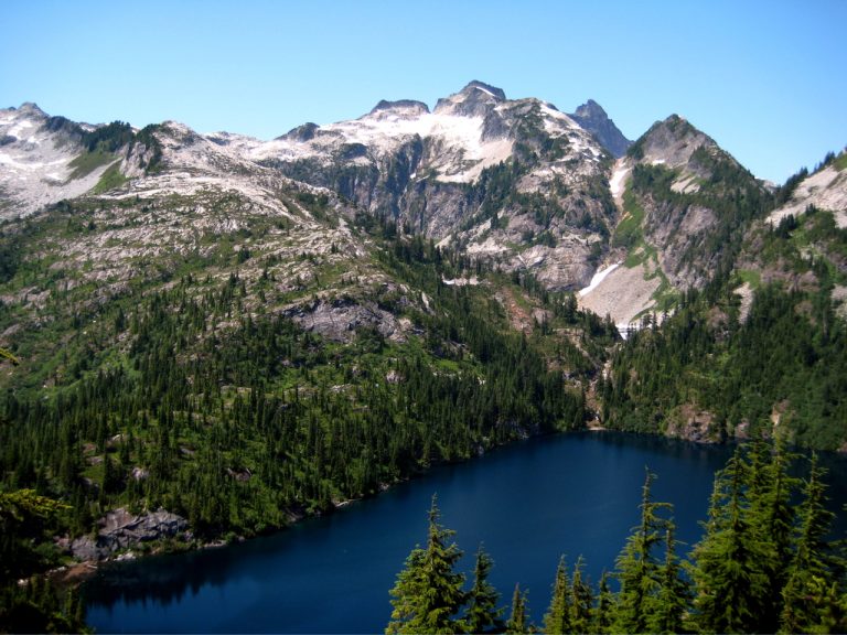 Craggy Thornton Peak stands over dark blue Thornton Lake in the Lower Skagit Mountains