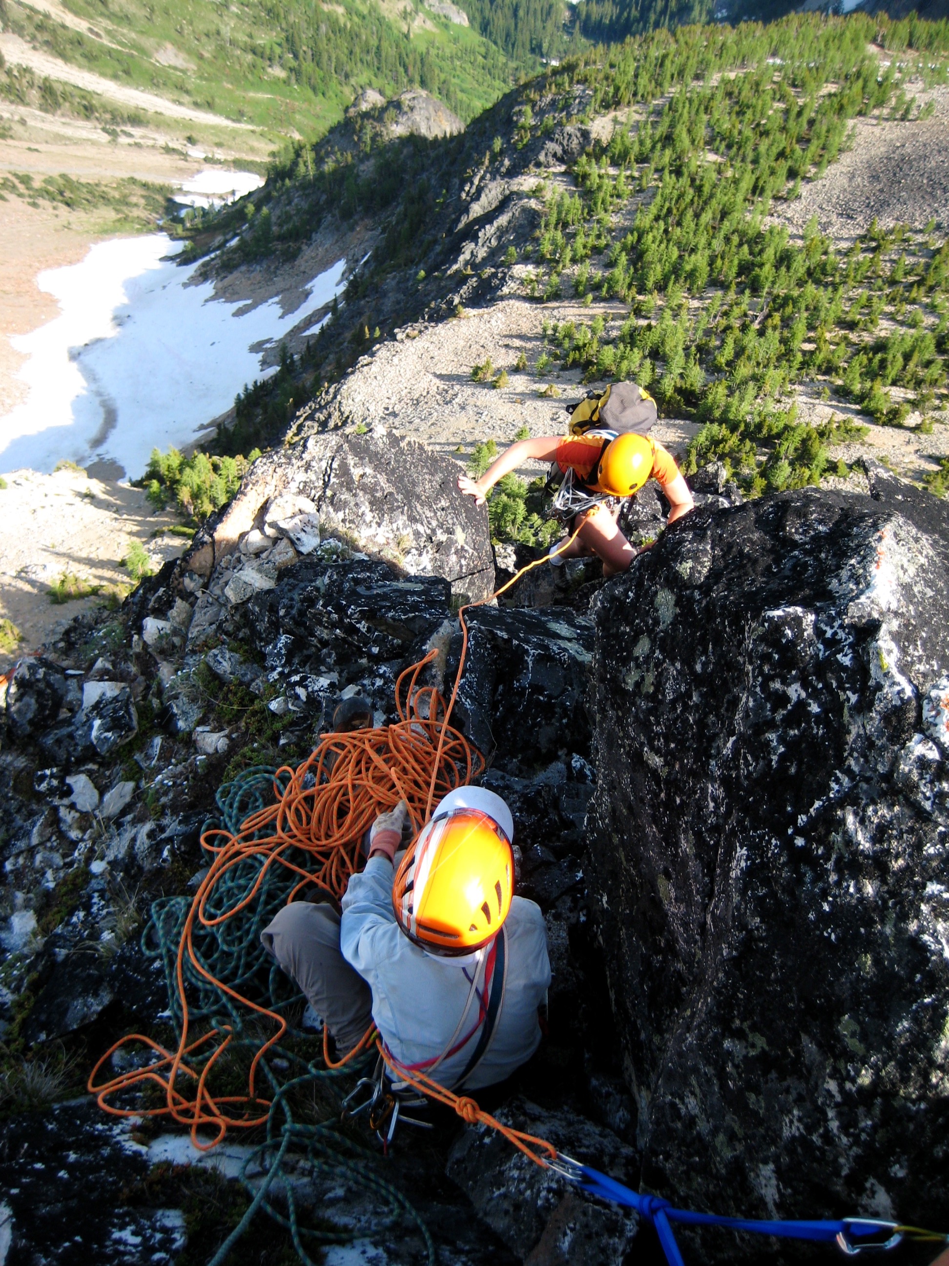 looking down on a mountain climber belaying a scrambling mountain climber on White Goat Peak in the Glacier Peak Wilderness
