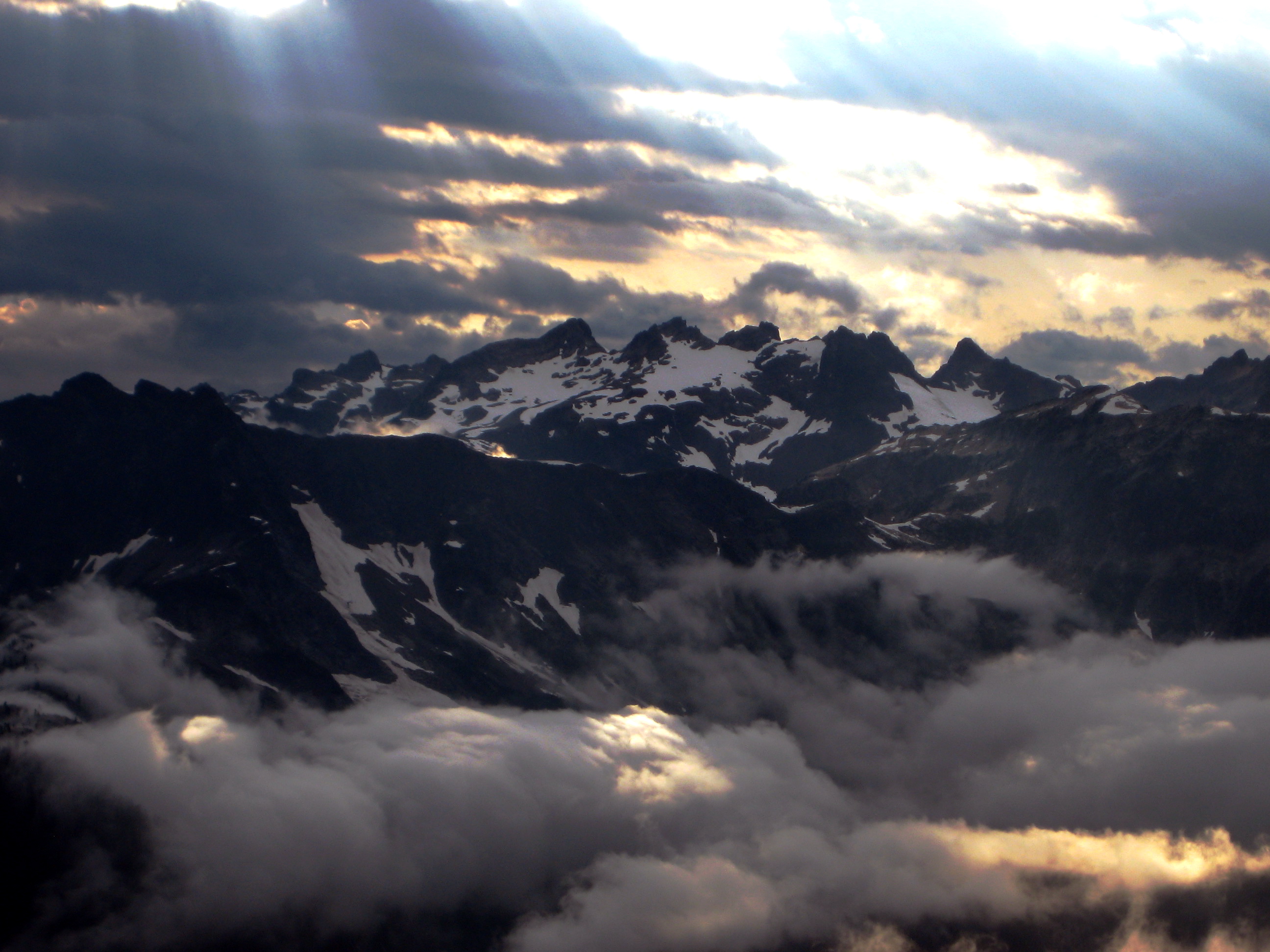 sun beams through storm clouds over Mt Hagan in the North Cascades