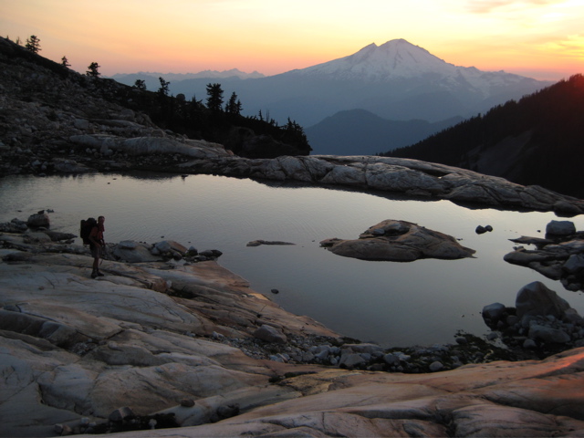 Sunset on Mt Baker with Upper Blum Lake and a climber in the foreground