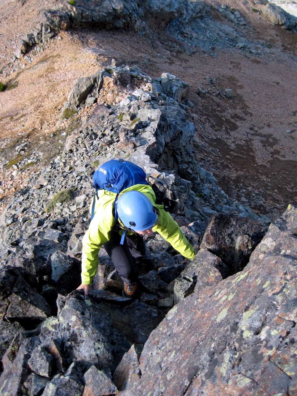 looking down on mountain climber scrambling rock face of The Citadel in the Alpine Lakes Wilderness