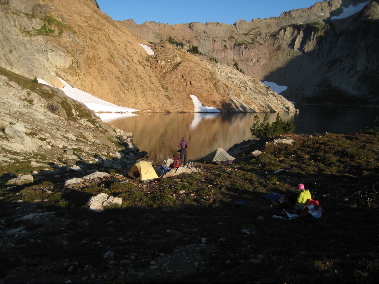 morning sun on mountain climber's camp at Circle Lake in the Alpine Lakes Wilderness with linguring snow patches