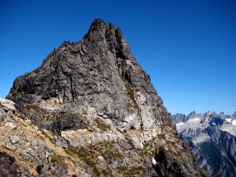 The triangular rocky summit of Mt Triumph juts into a blue sky