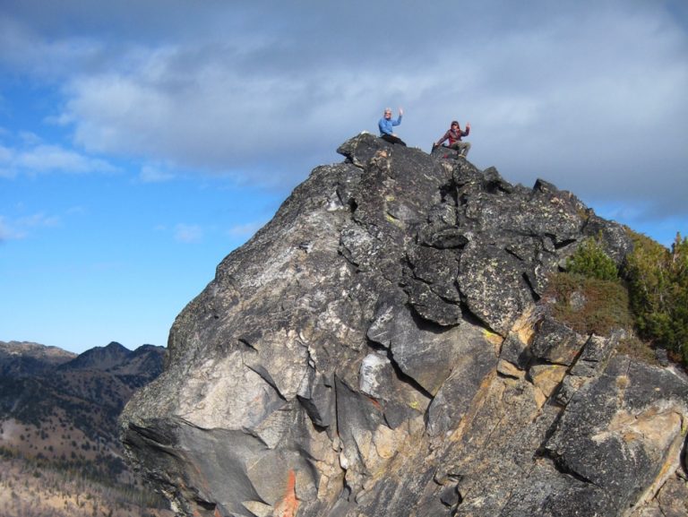 Two climbers stand atop Ferry Peak in the Sawtooth Mountains