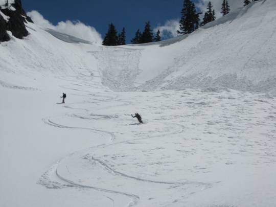 two skiers make telemark turns down broad snow slopes below Melakwa Pass on the Chair Peak Ski Circumnavigation