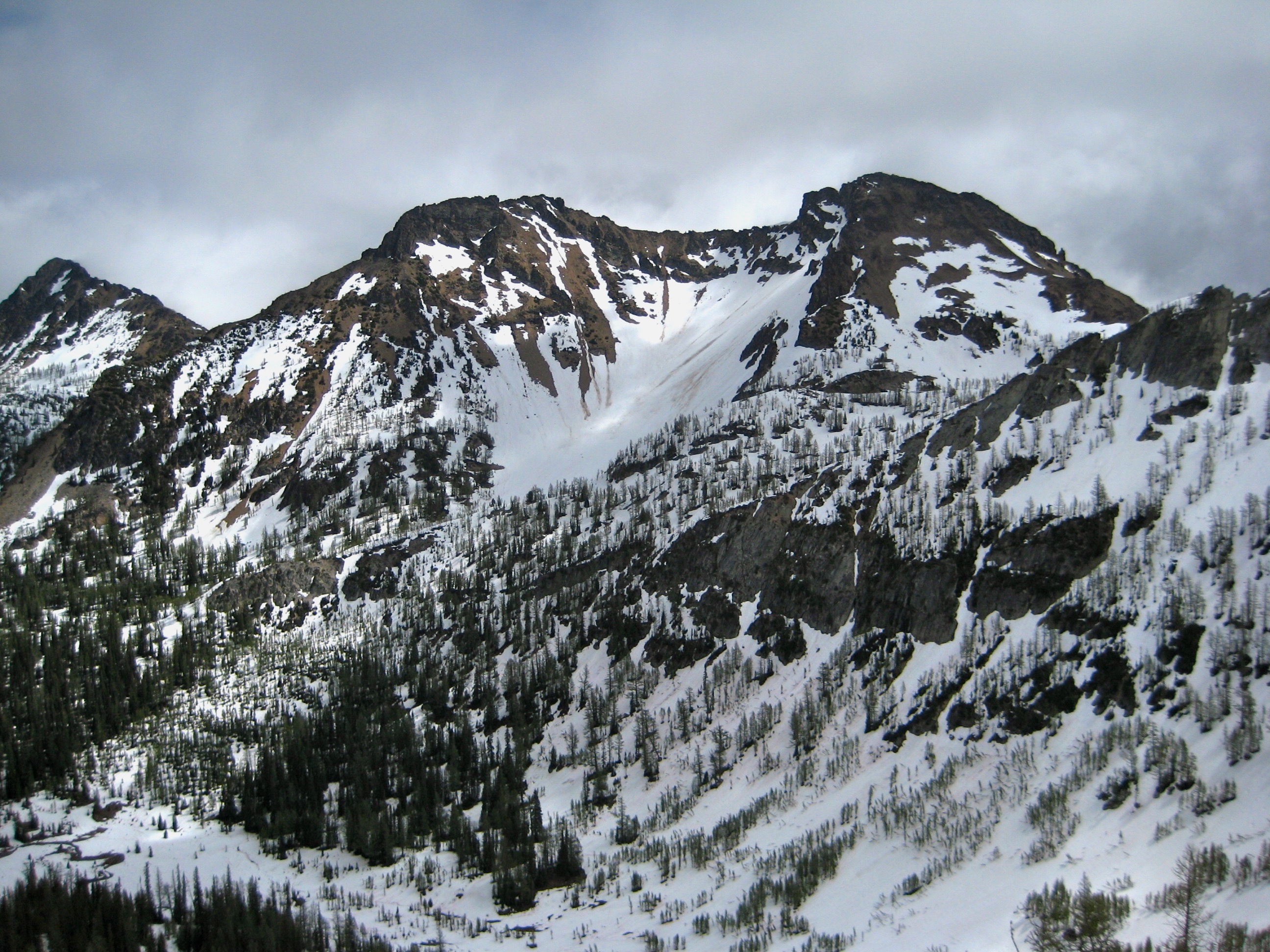 bare rock ridge of Flora Mountain sits above snow filed Castle Creek Basin in the Stehekin Mountains