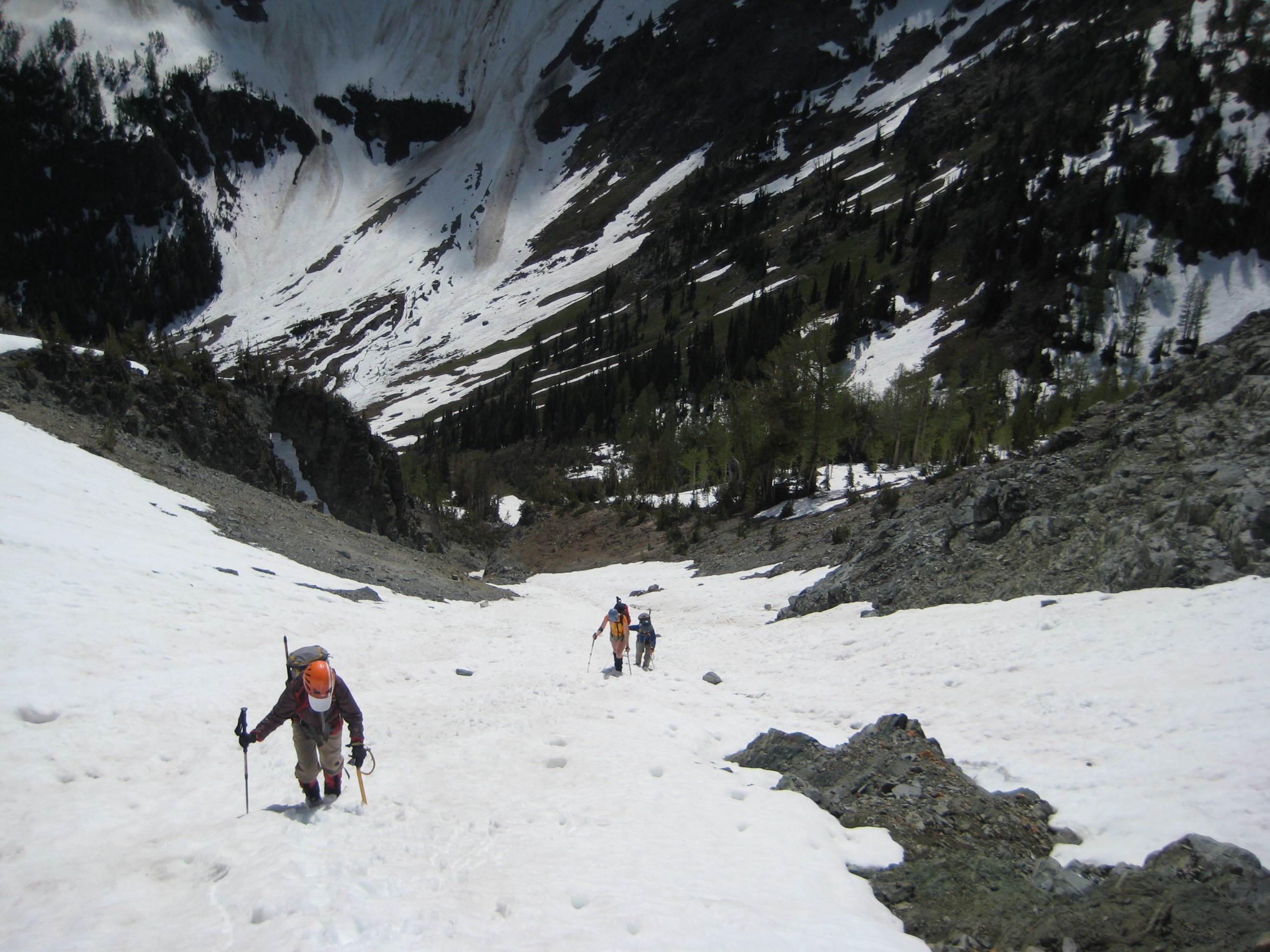 looking down on mountain climbers booting up snow filled couloir leading to Black Tower Mountain in the Glacier Peak Wilderness