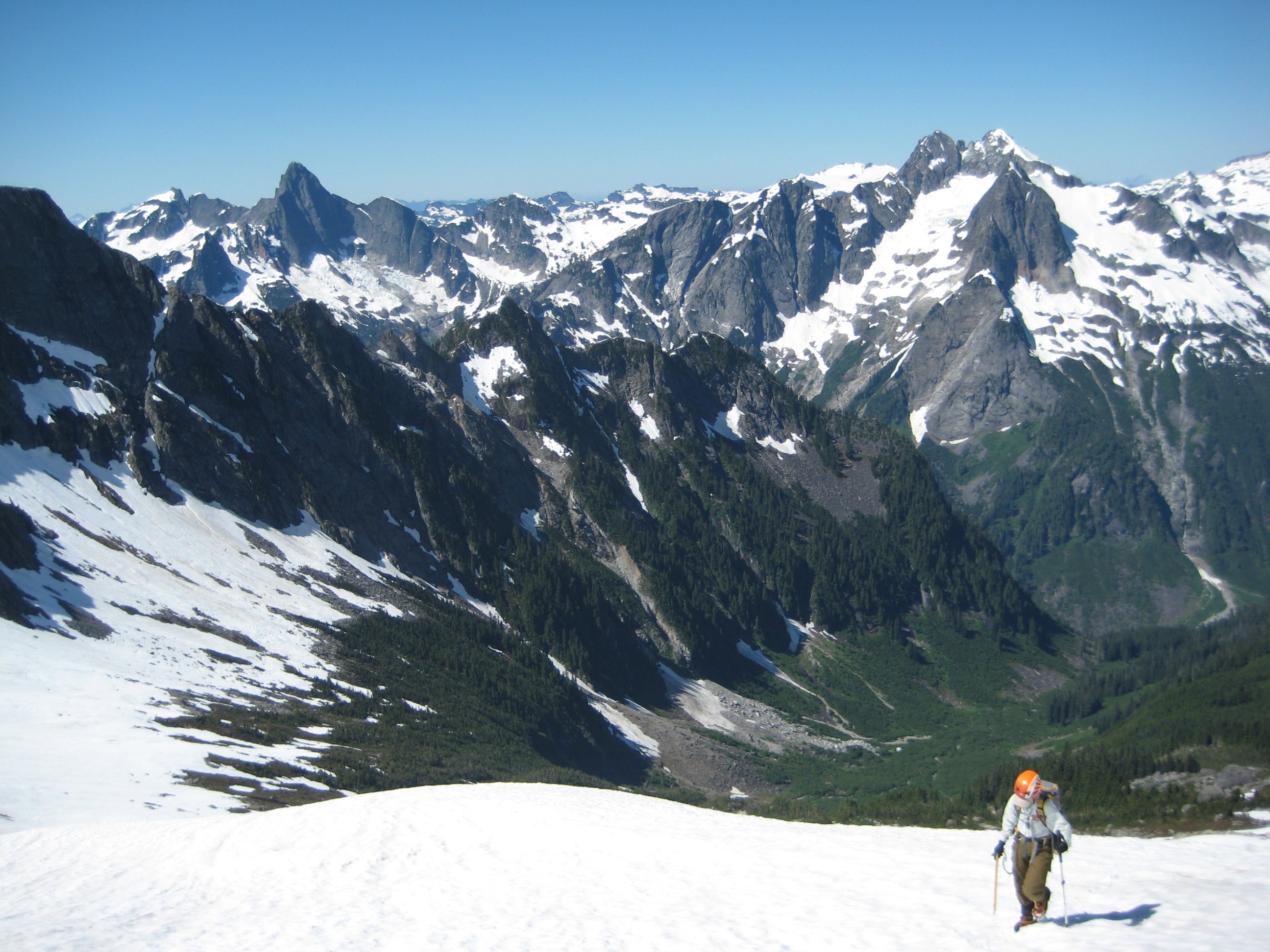 mountain climber booting up snow above Crescent Creek Valley with Mt Triumph in the background