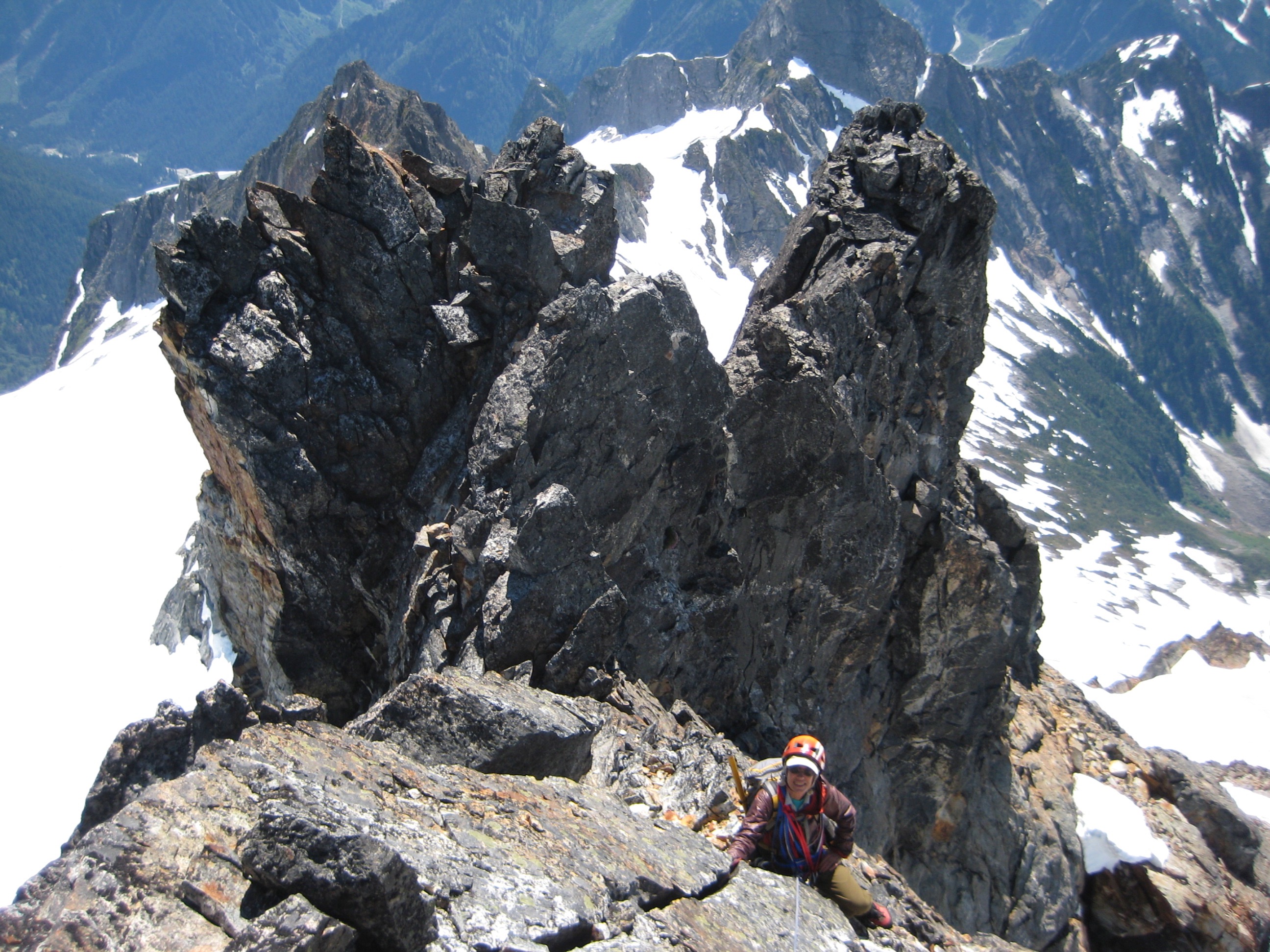 Mountain climber on the rocky final pitch of Mt Degenhardt with rocky pinnacles in the background