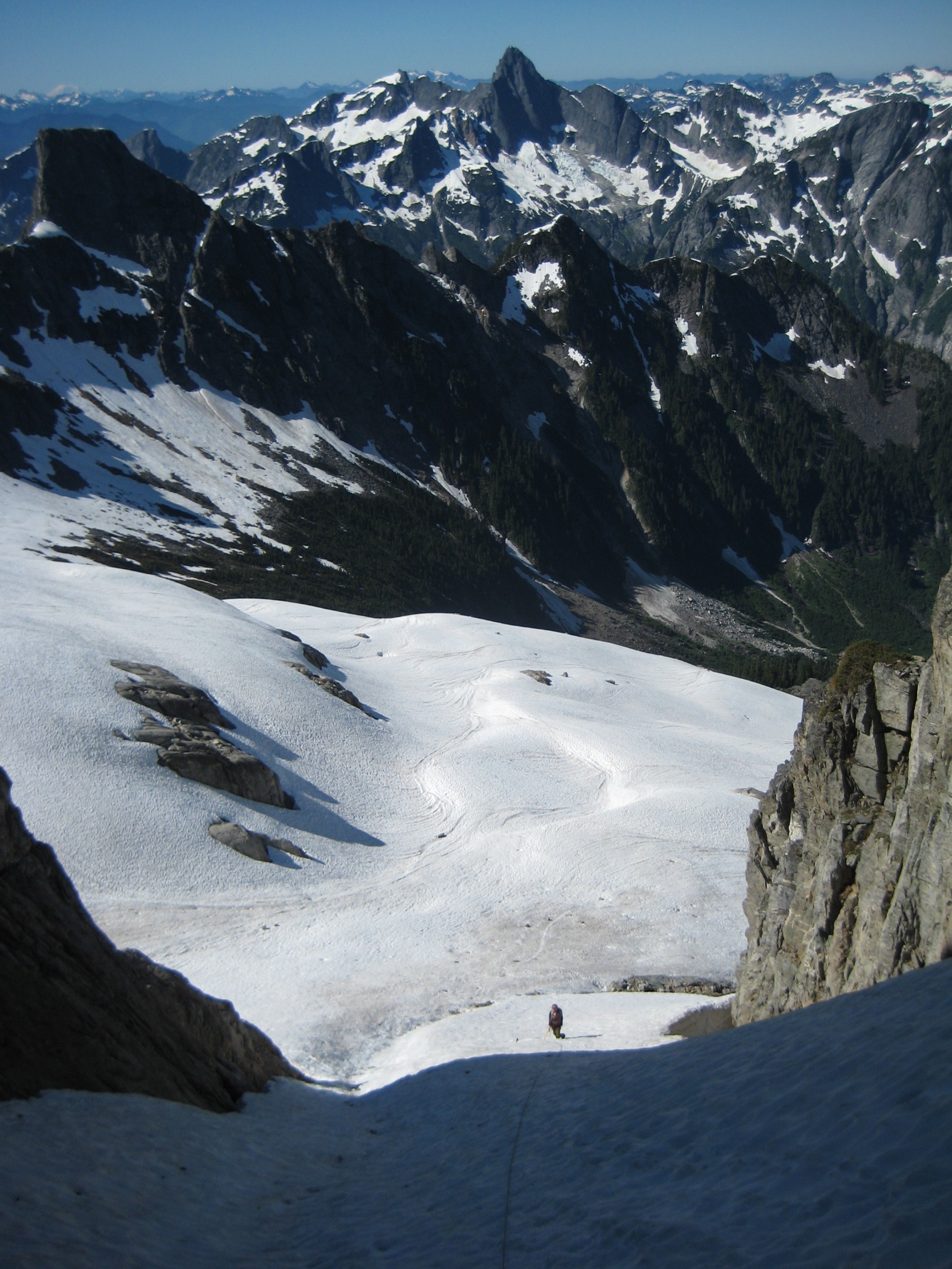 mountain climber booting up the Mt Terror snow couloir with Mt Triumph in the background