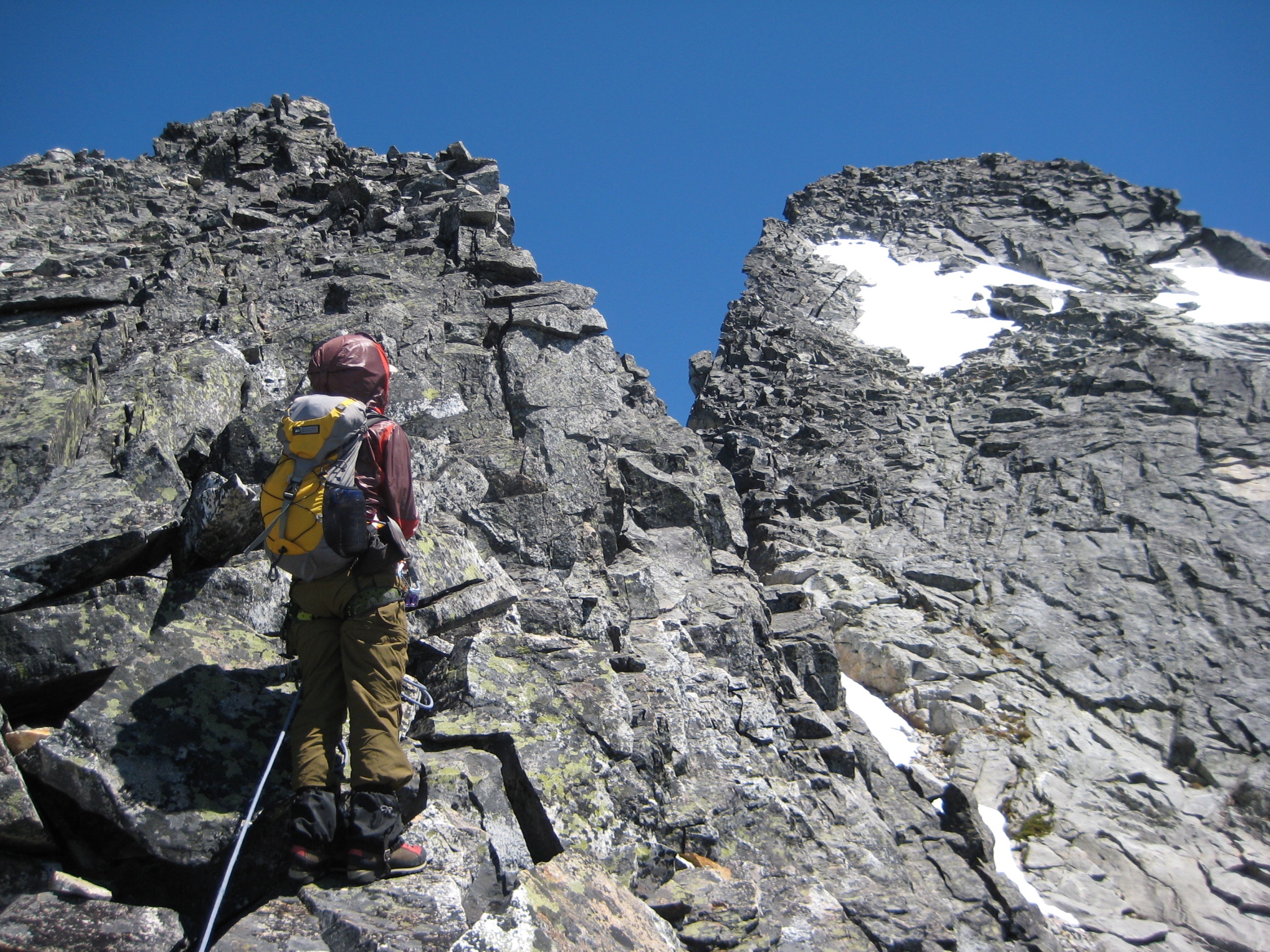 mountain climber scrambling toward a notch on the ridge of Mt Terror