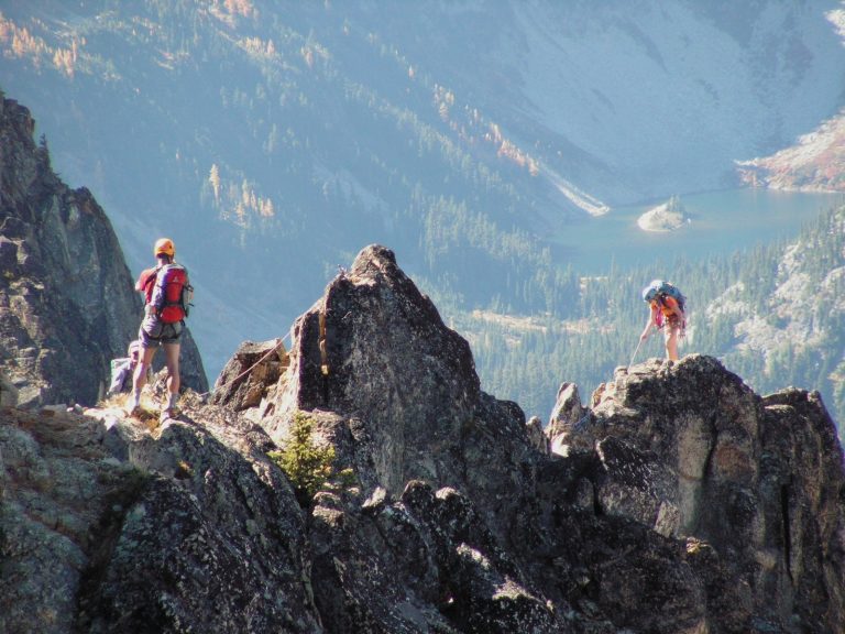 Two rock climbers ascend a steep jagged granite ridge on Cutthroat Peak