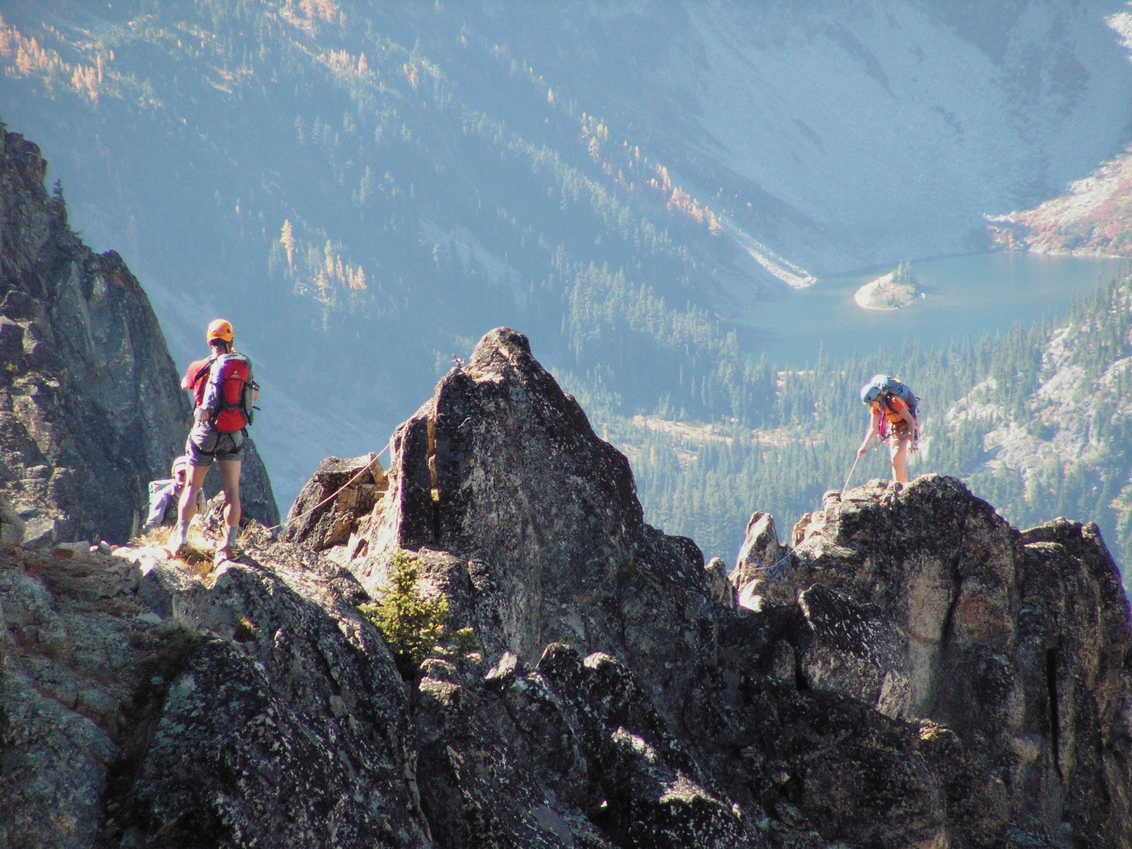 Two rock climbers ascend a steep jagged granite ridge on Cutthroat Peak