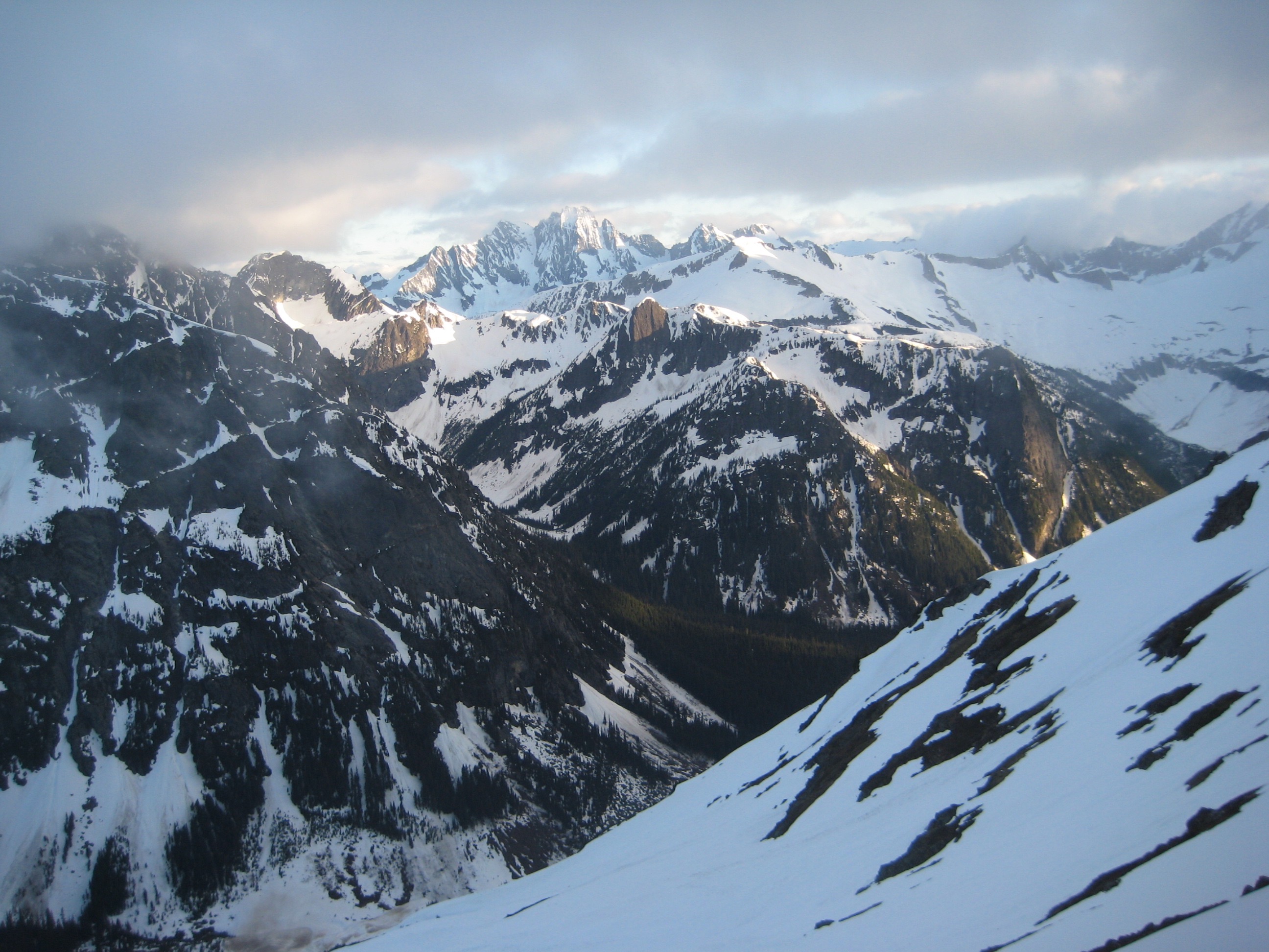 evening light on distant snowy North Cascades mountains with high clouds