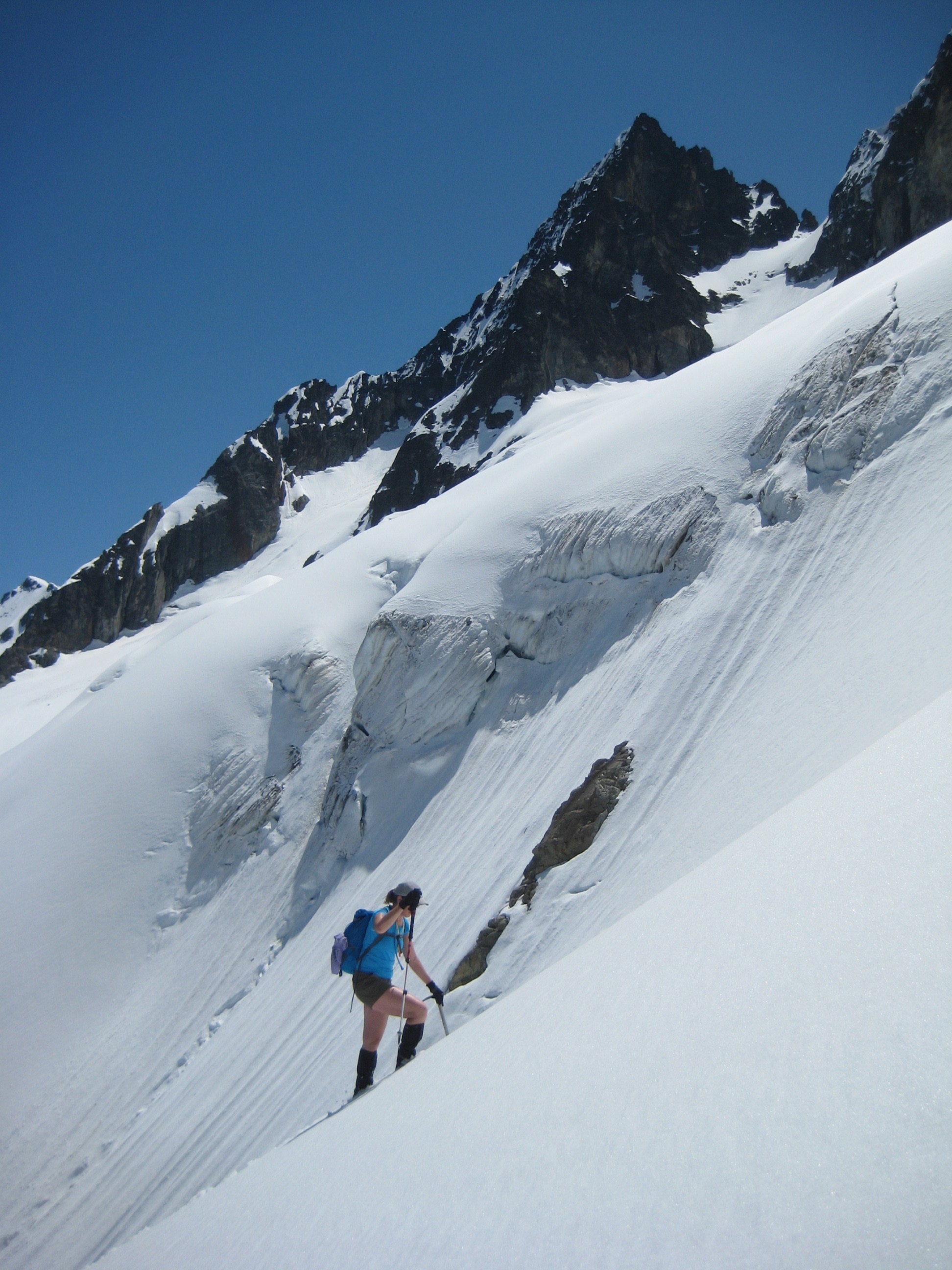 mountain climber booting up the Katsuk Glacier in the North Cascades with the summit of Mesahchie Peak in the background