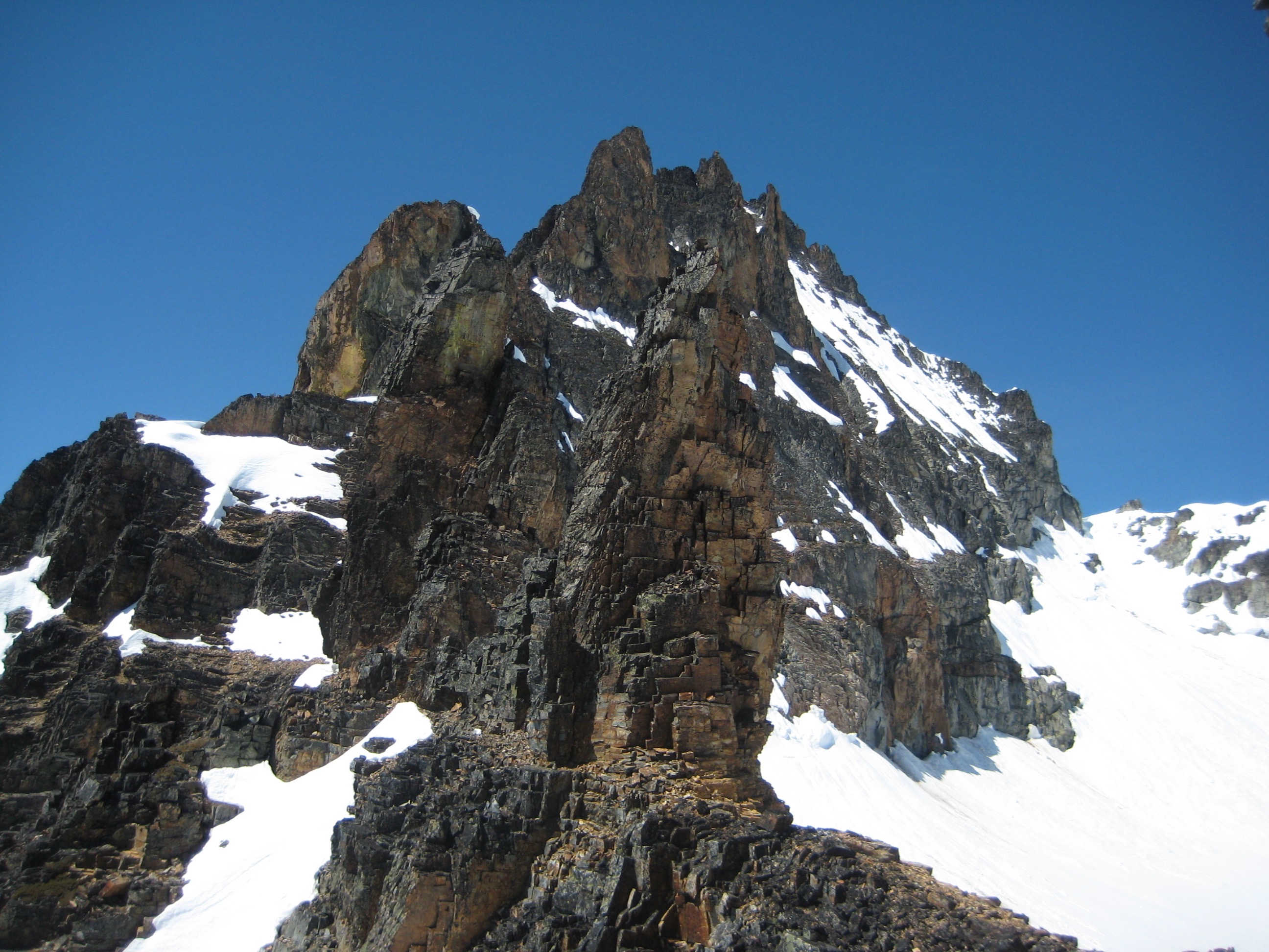 Grotesque Gendarmes with snow patches and the summit of Kimtah Peak in the North Cascades