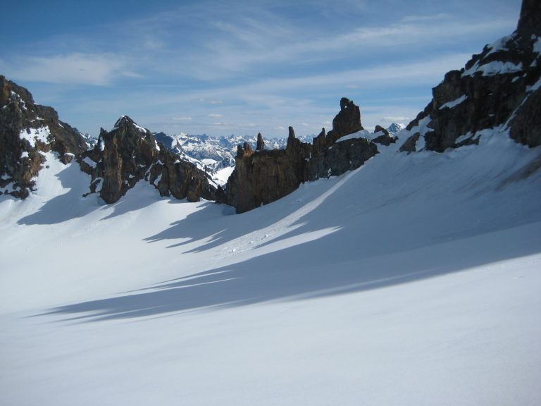 A row of sharp pinnacles on Kimtah Peak casts a shadow on Katsuk Glacier in the North Cascades