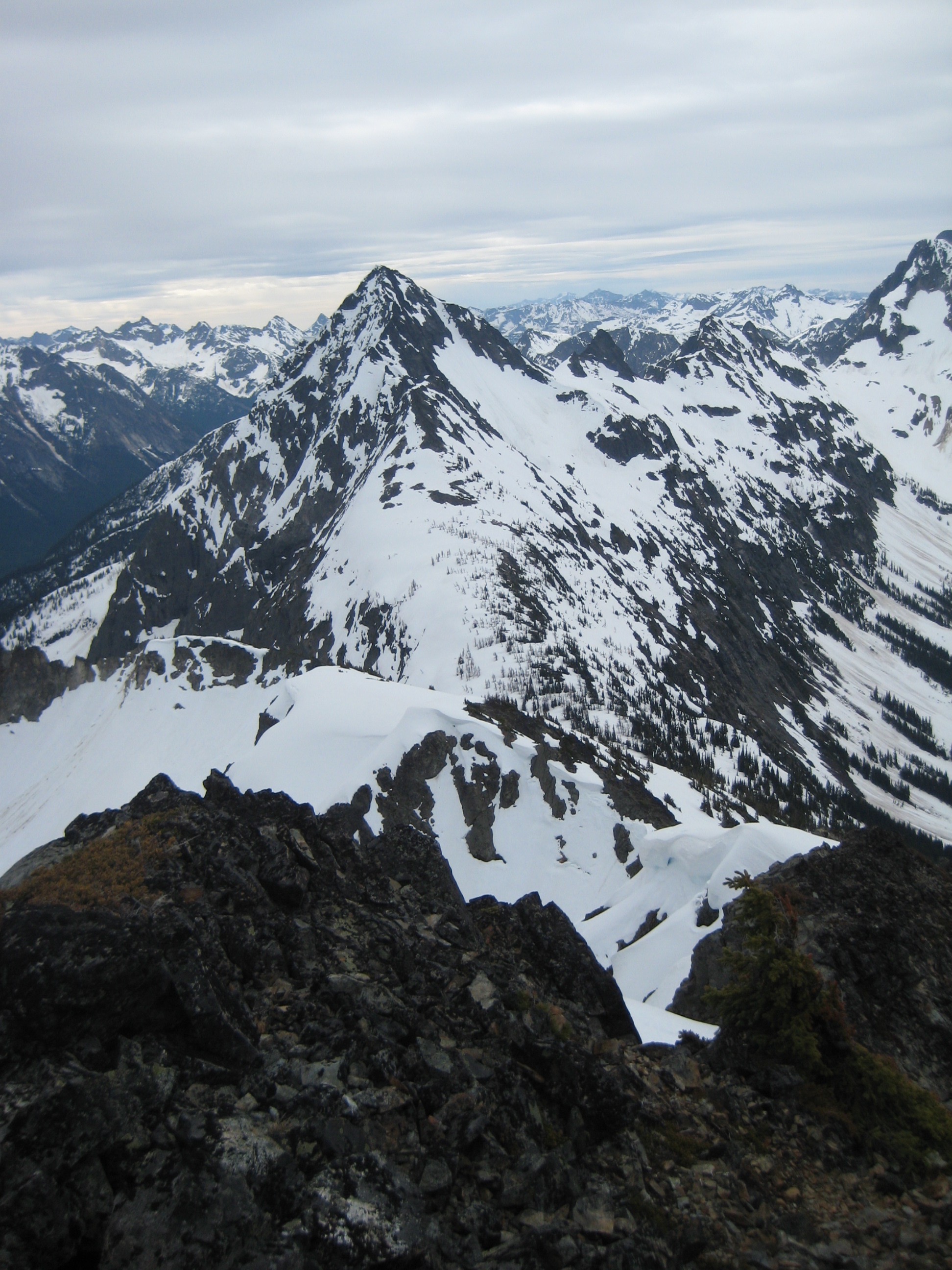 snow covered Graybeard Peak in the North Cascades with rock outcroppings in the foreground