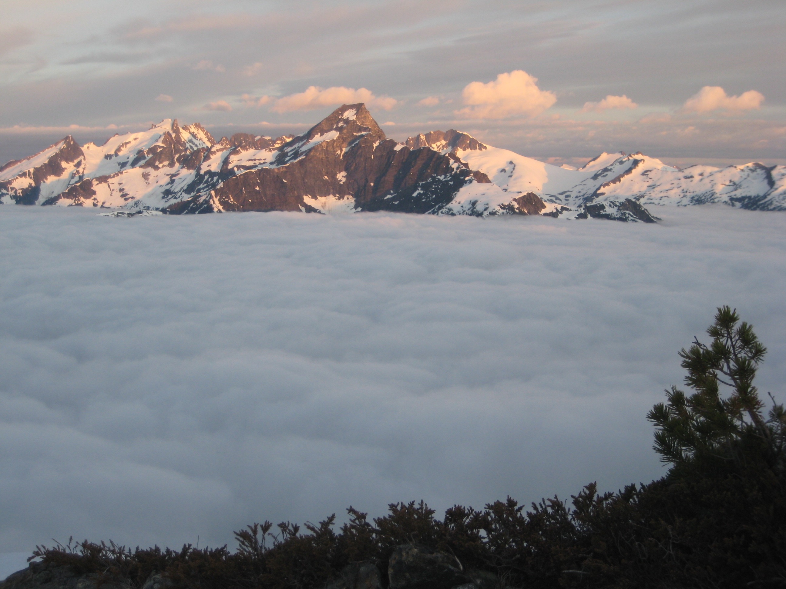 morning light on the Northern Picket Range in North Cascades National Park above valley fog as seen from climbers camp on Mt Prophet