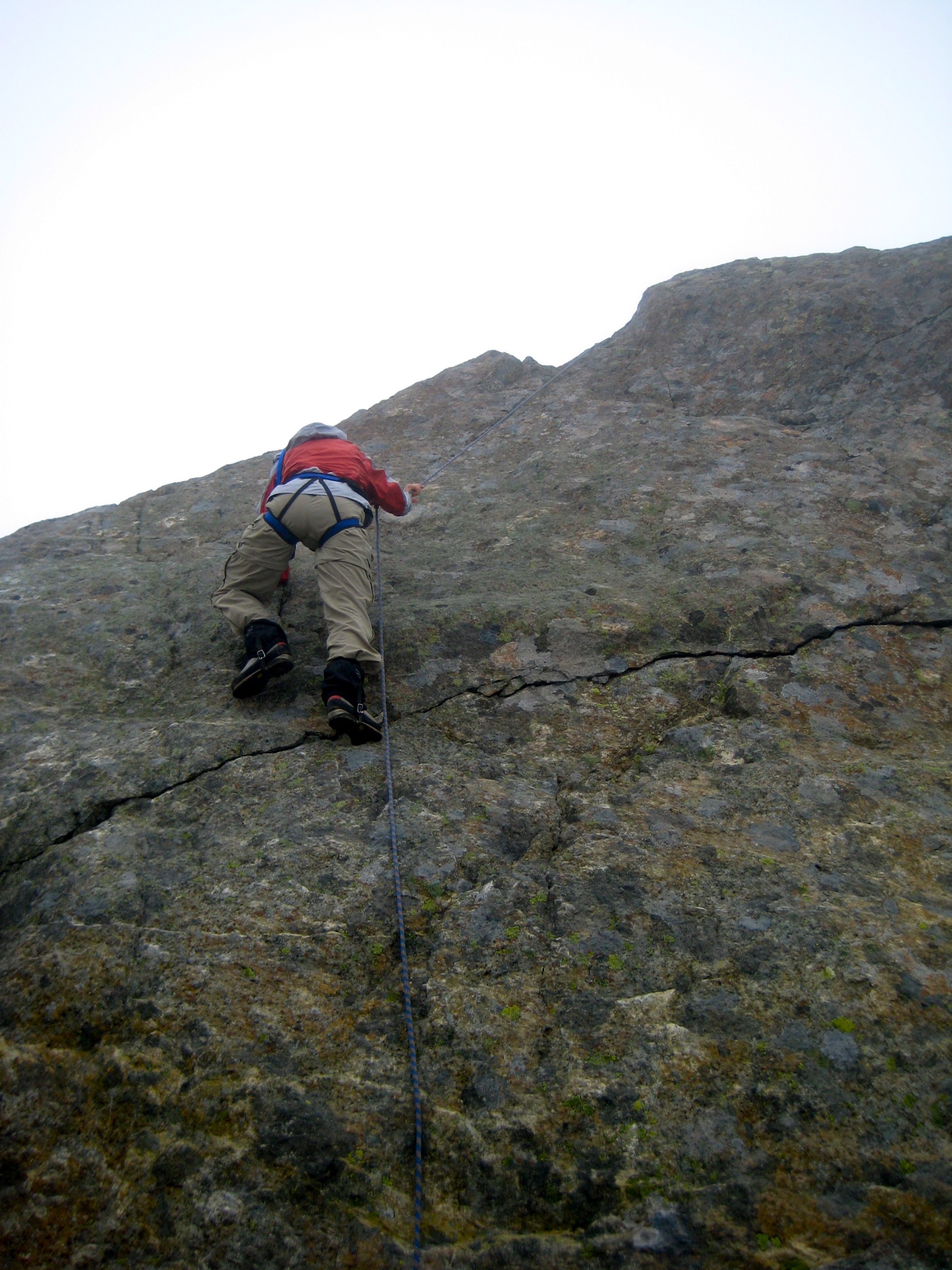 climber scrambling step rock summit horn on North Brother in the Olympic Mountains