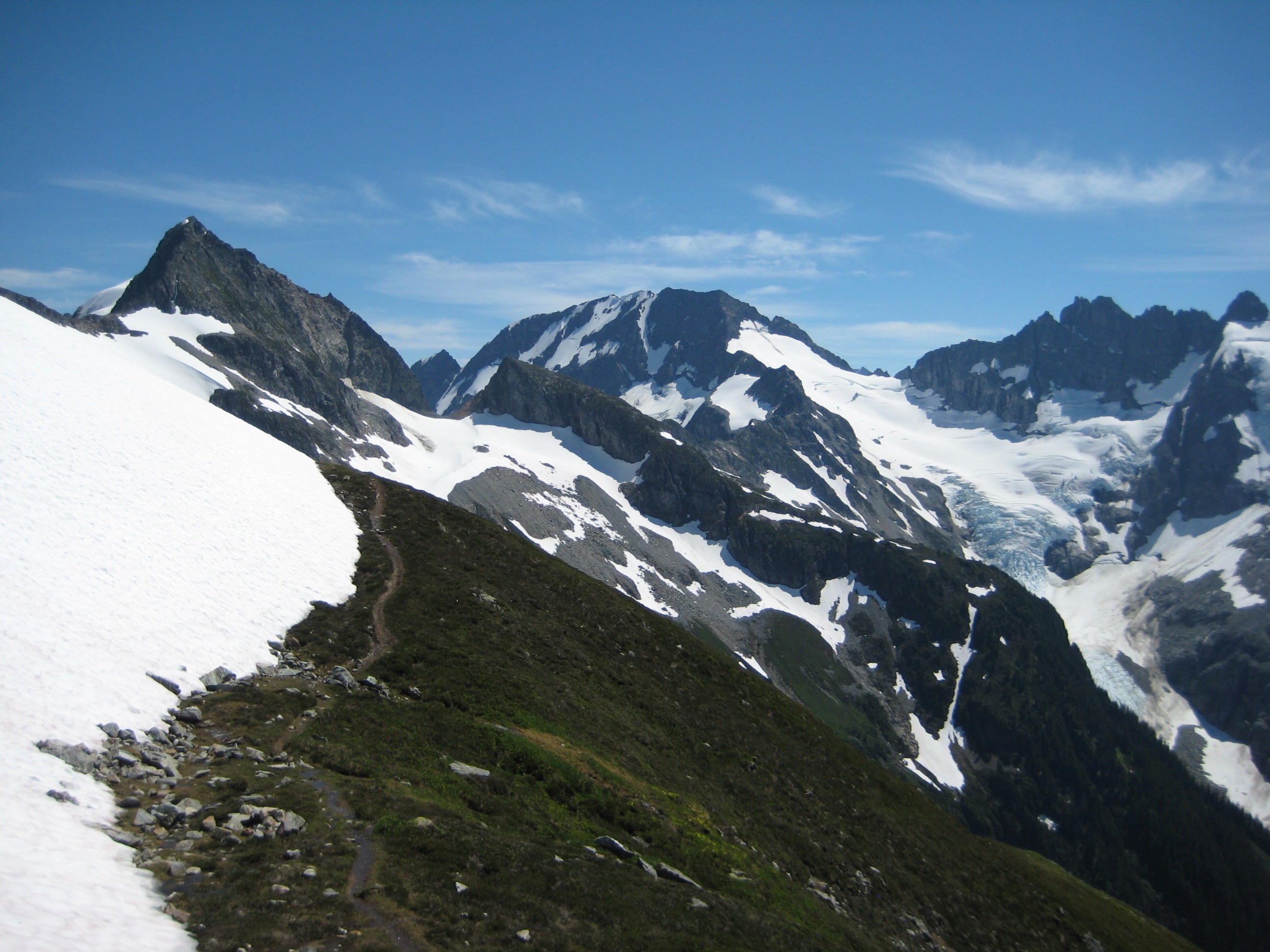 Hurry-Up Peak and Arts Knoll in the distance with a large snow field just above the trail at the start of the Ptarmigan Traverse