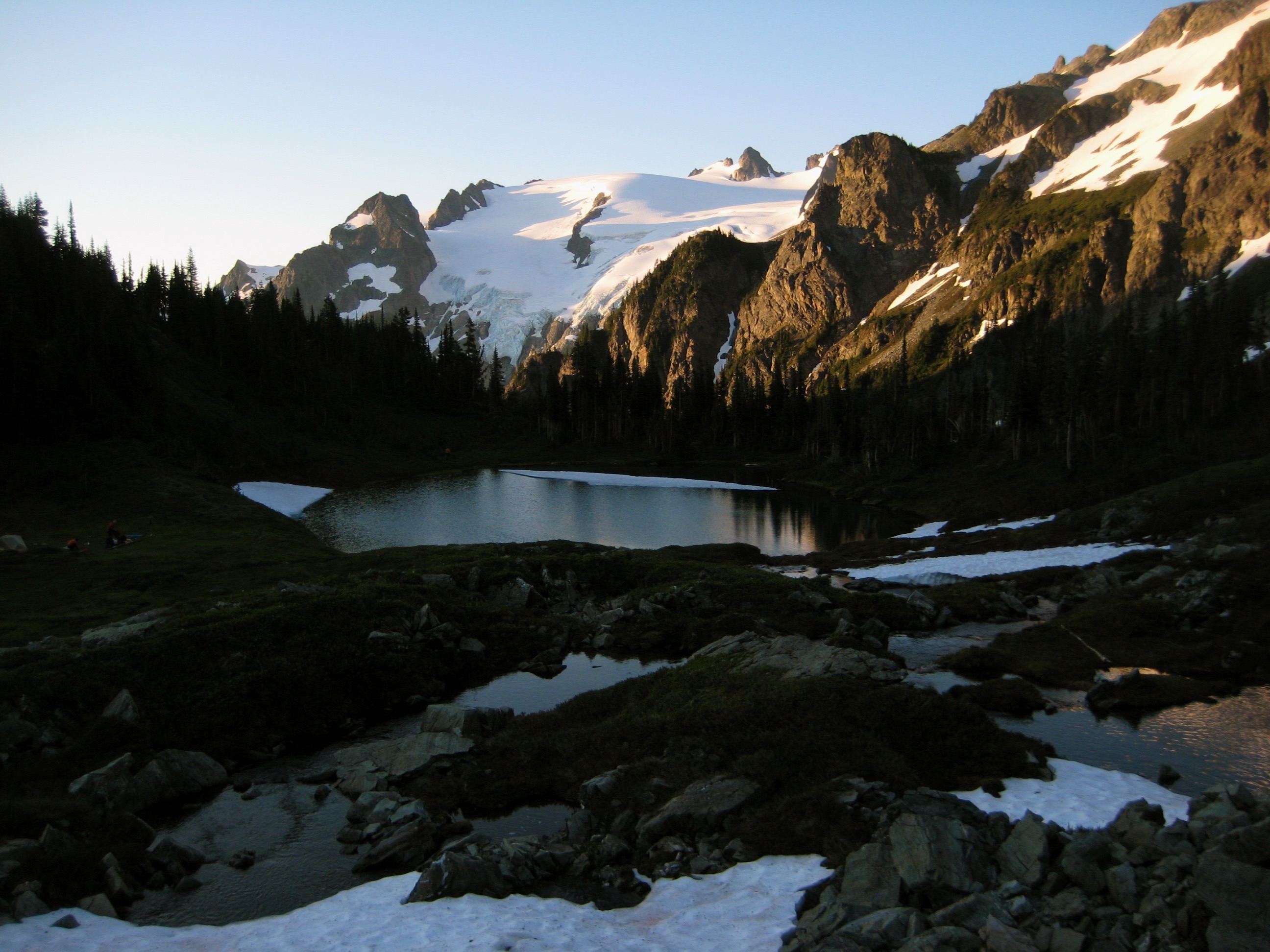 morning light on Yang Yang Lakes with linguring snow patches and Old Guard Peak in the Ptarmigan Mountains