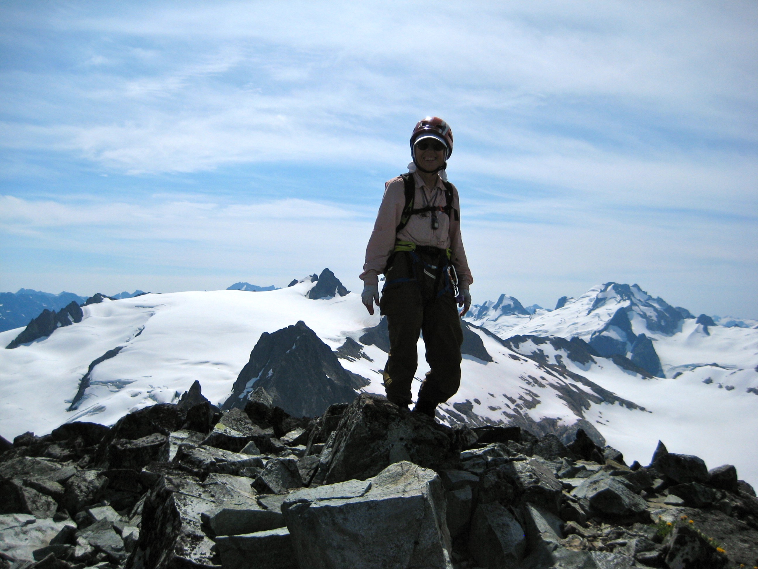mountain climber standing on the rocky summit of LeConte Mountain with the Ptarmigan Traverse in the background