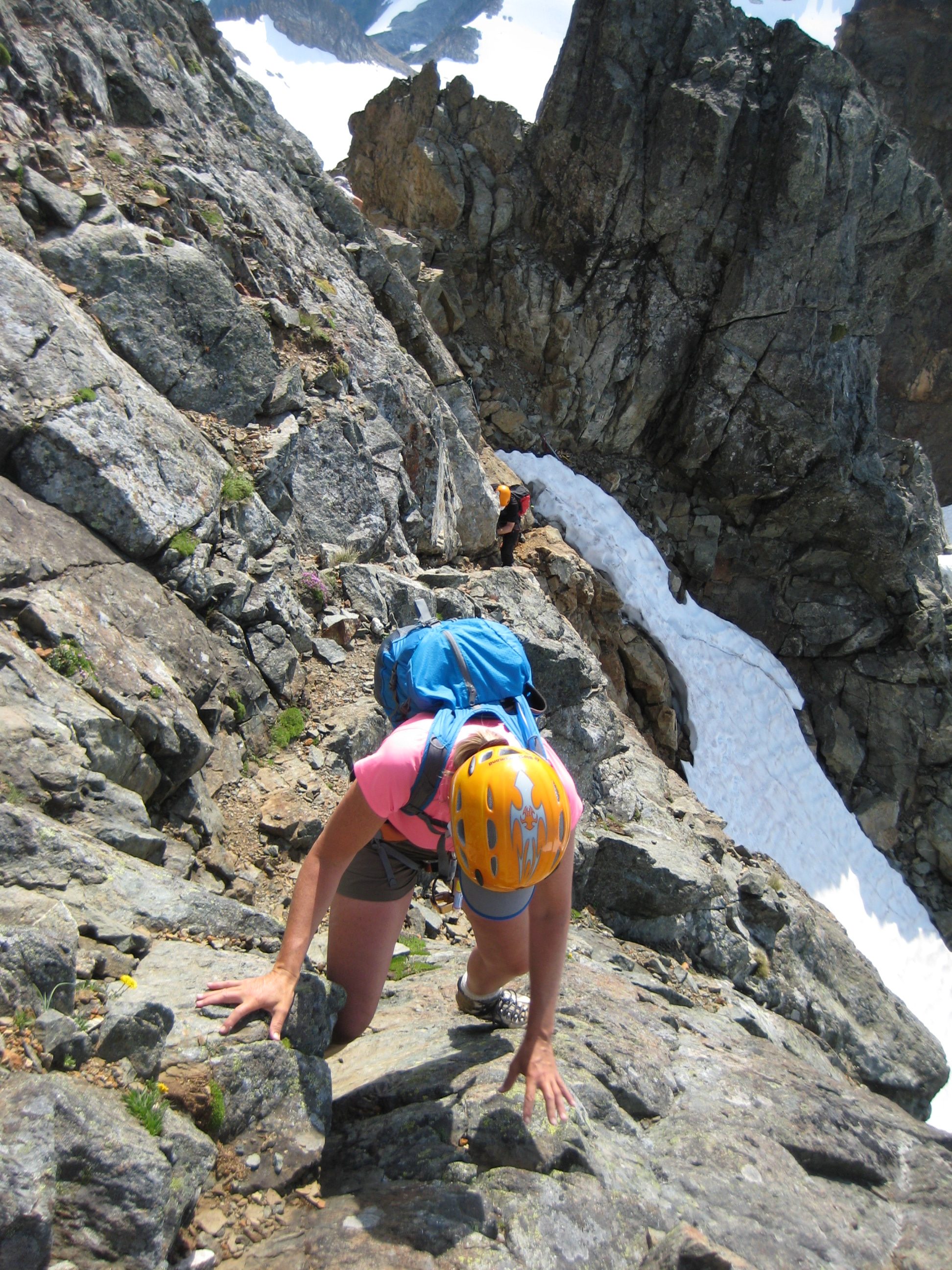 mountain climbers scrambling a rock ledge near the summit of Old Guard Peak in the Ptarmigan Mountains