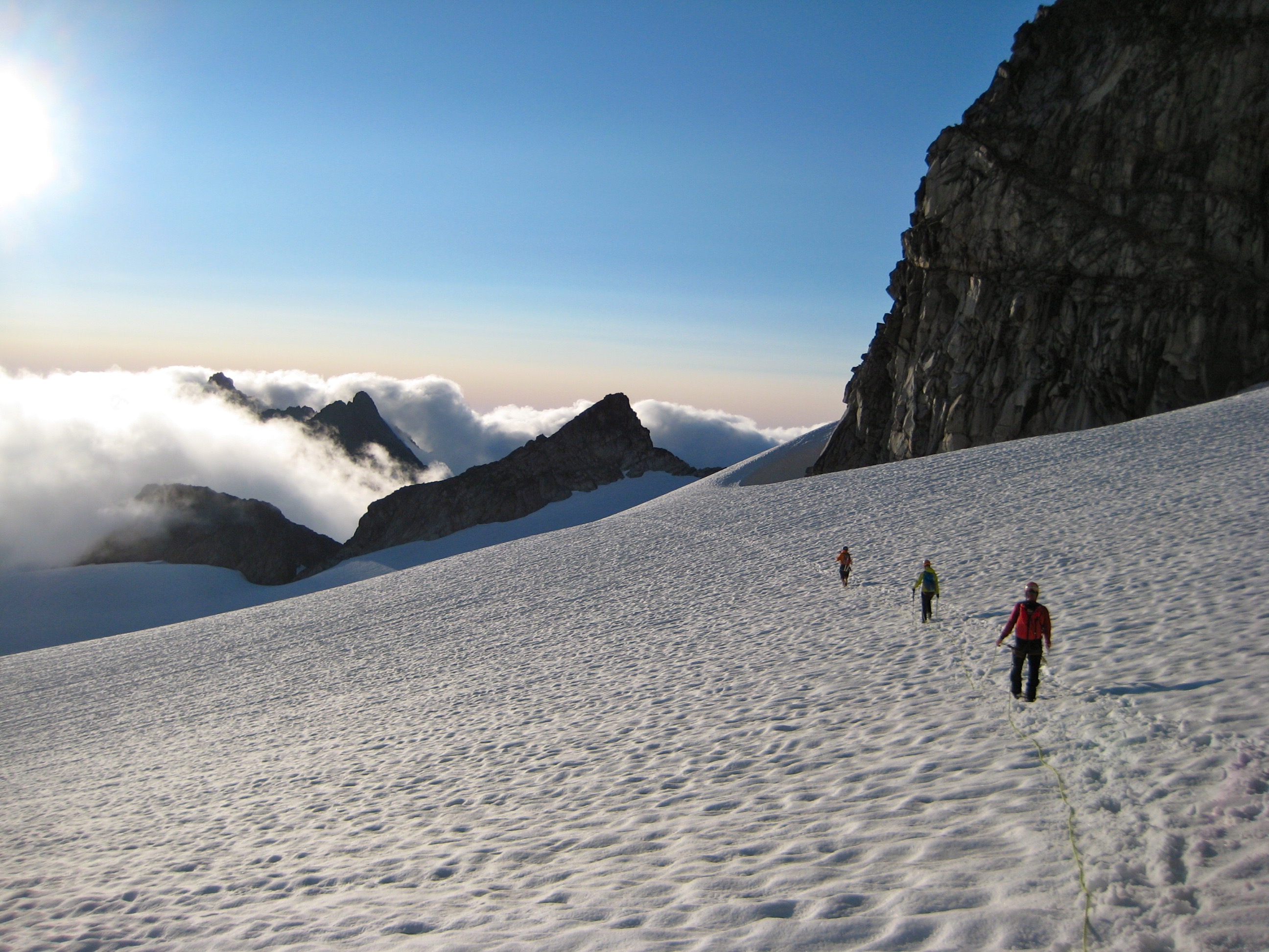 roped mountain climbers descending Dome Glacier in the evening light on the Ptarmigan Traverse