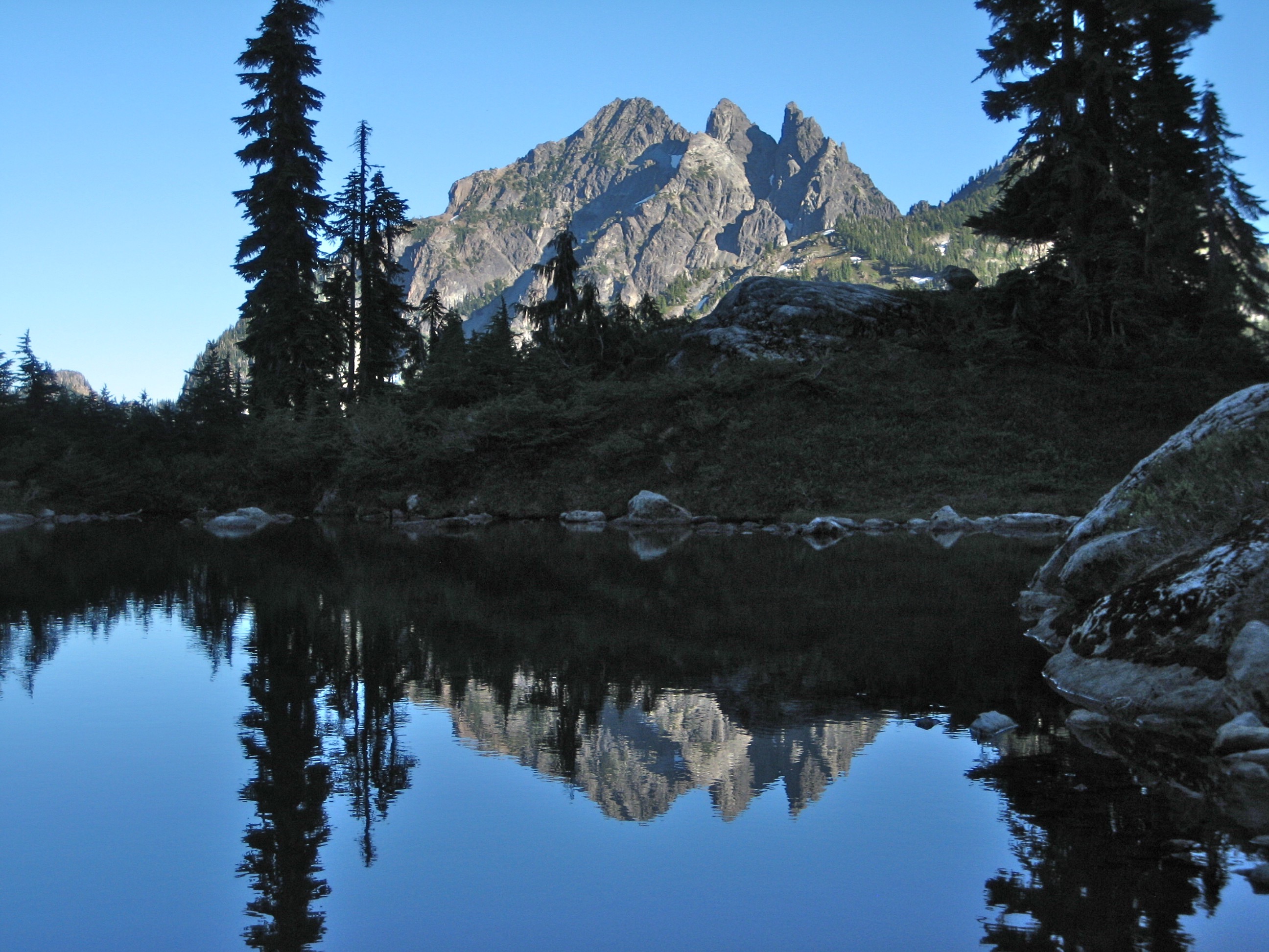 Three Queens Mountain reflecting in a tarn near Glacier Lake