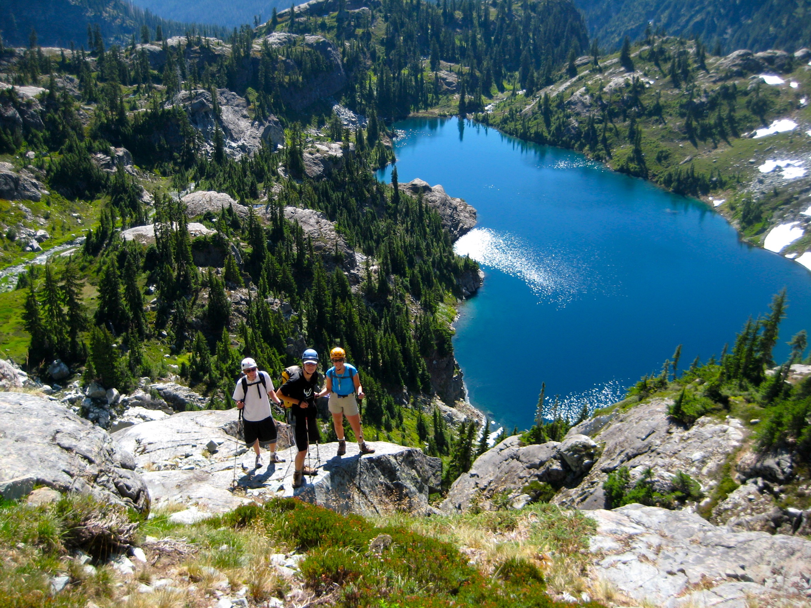 climbers standing on heather above Glacier Lake in the Alpine Lakes Wilderness