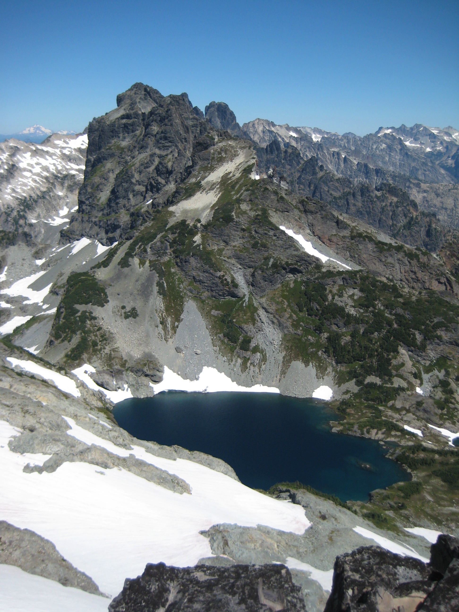 rocky summit horn of Lemah Mountain high above Chikamin Lake as seen from the summit of Chikamin Peak