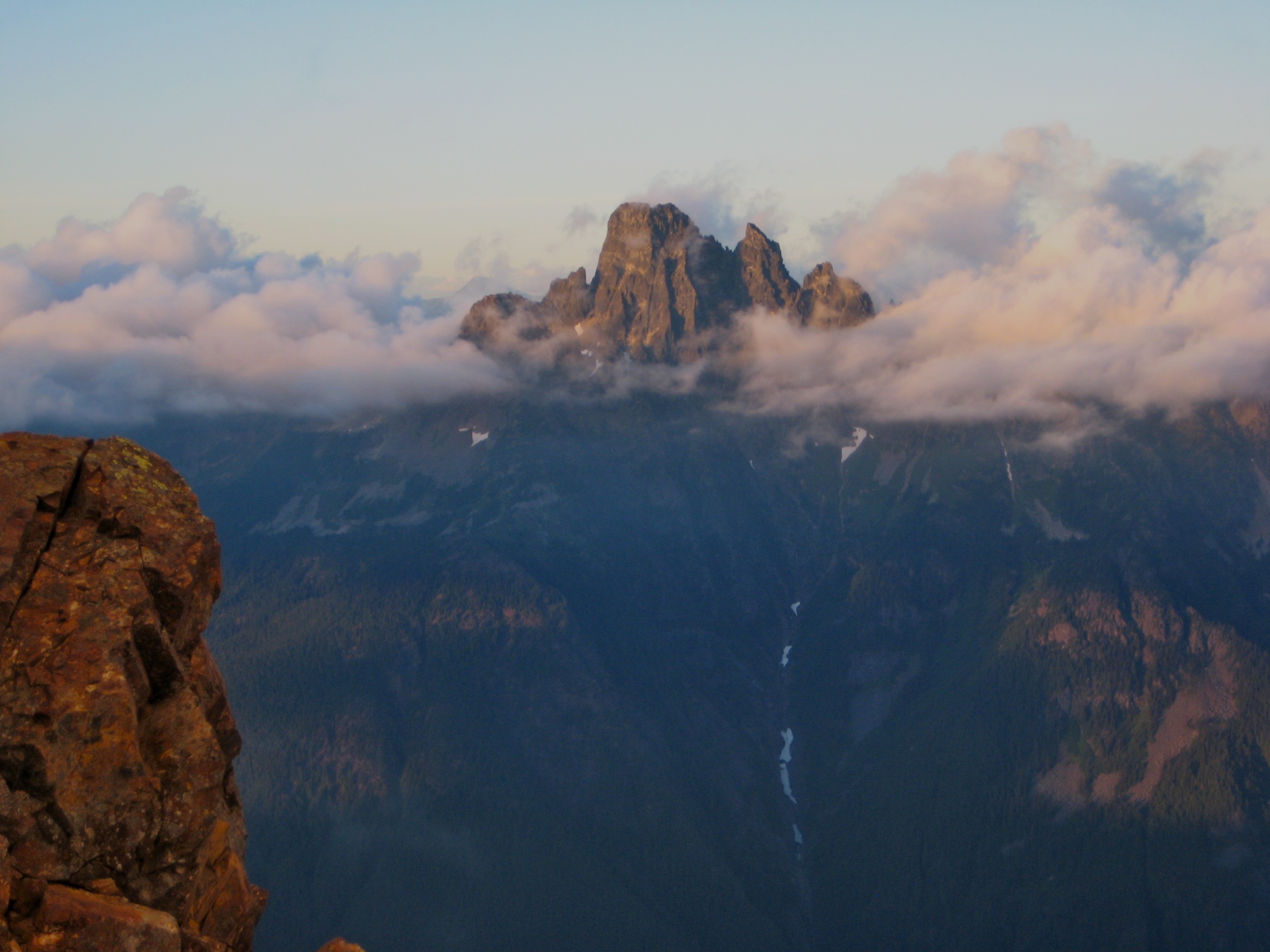 Mt Slesse in British Columbia Canada sticking out of the evening clouds as seen from American Border Peak